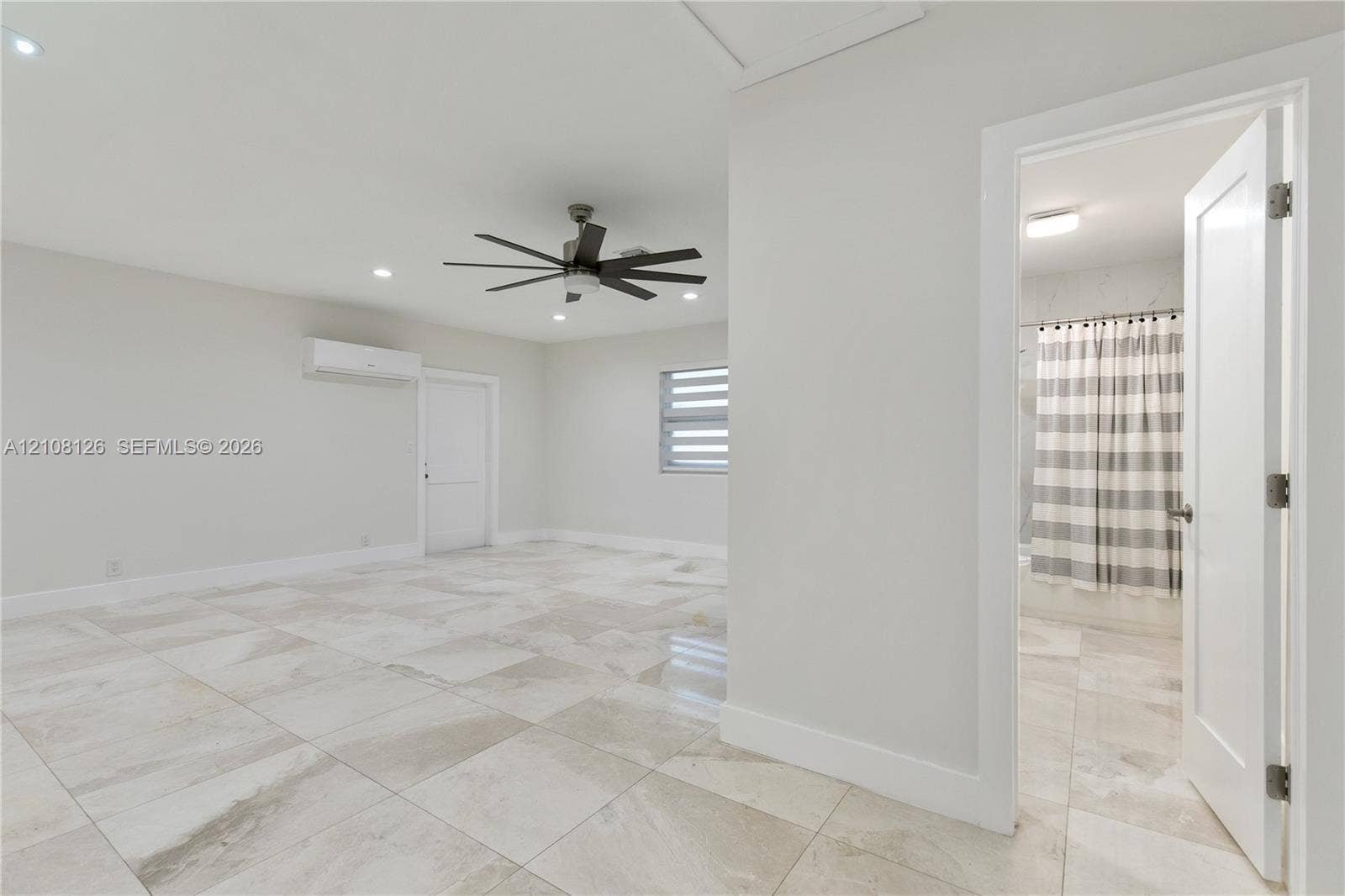 11700 NW 4th Street, Plantation, Plantation, FL 33325 Large-format tile flooring, multi-blade ceiling fan, recessed lighting, wall-mounted air conditioning unit, and dual-pane window