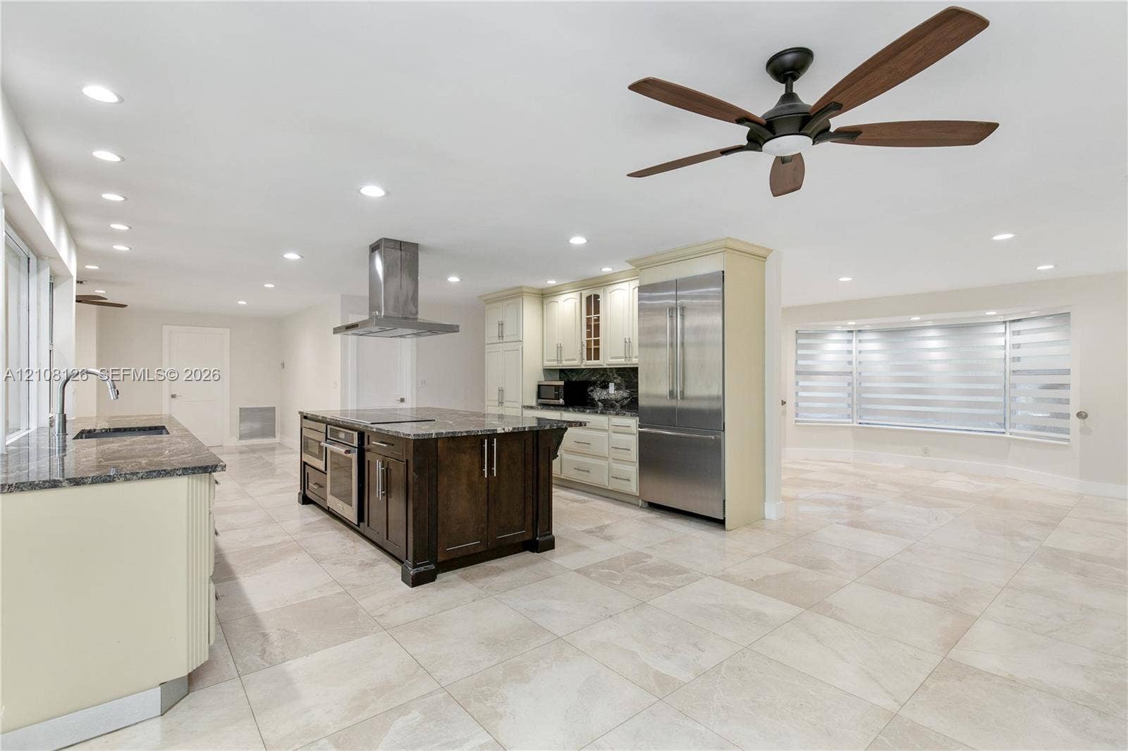 11700 NW 4th Street, Plantation, Plantation, FL 33325 Kitchen featuring a center island with dark wood-finish cabinetry, stainless steel appliances, a stainless steel range hood, stone countertops, and tile flooring