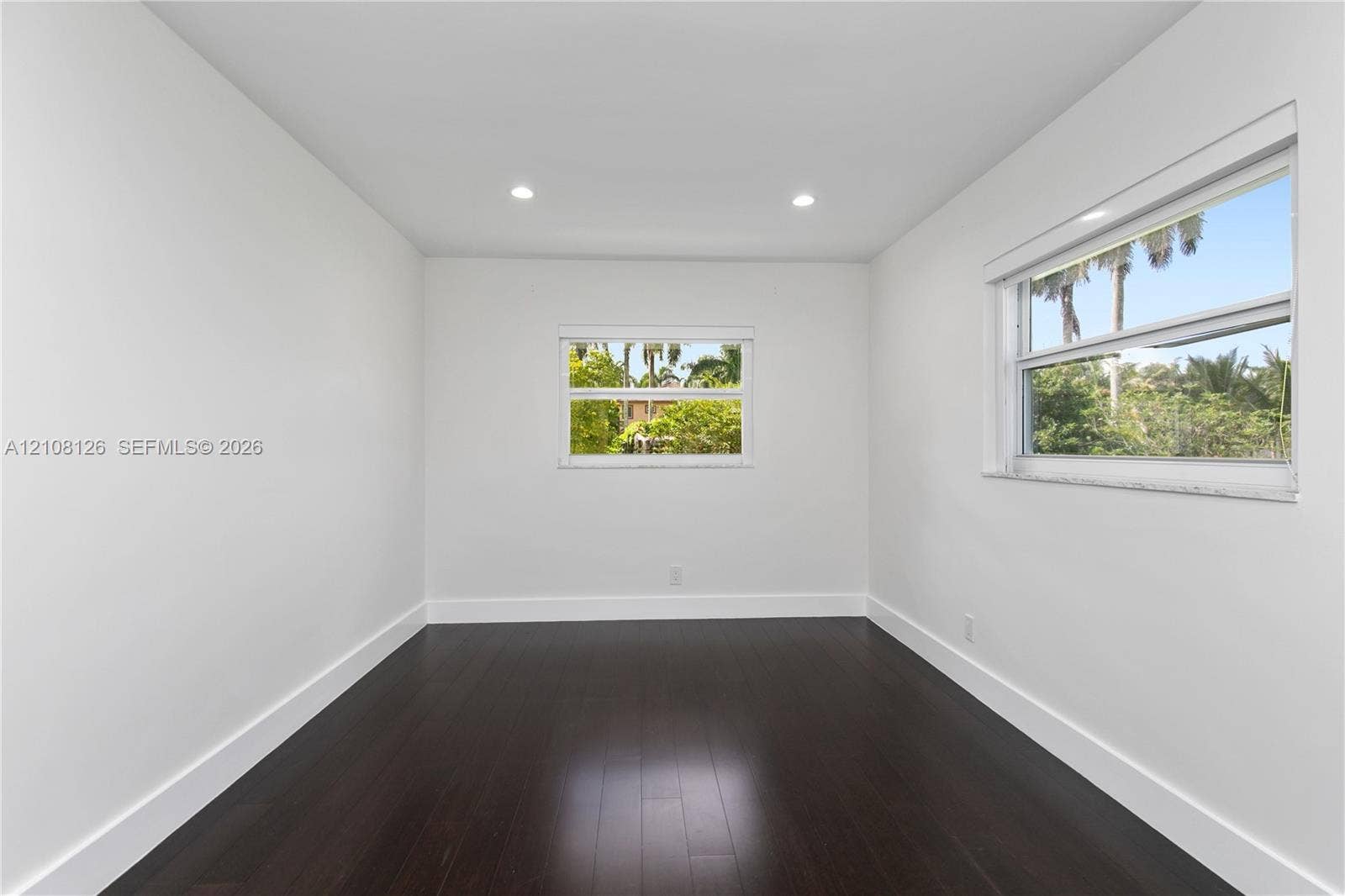 11700 NW 4th Street, Plantation, Plantation, FL 33325 Interior space featuring dark wood-finish flooring, white walls, recessed ceiling lighting, and horizontal sliding windows