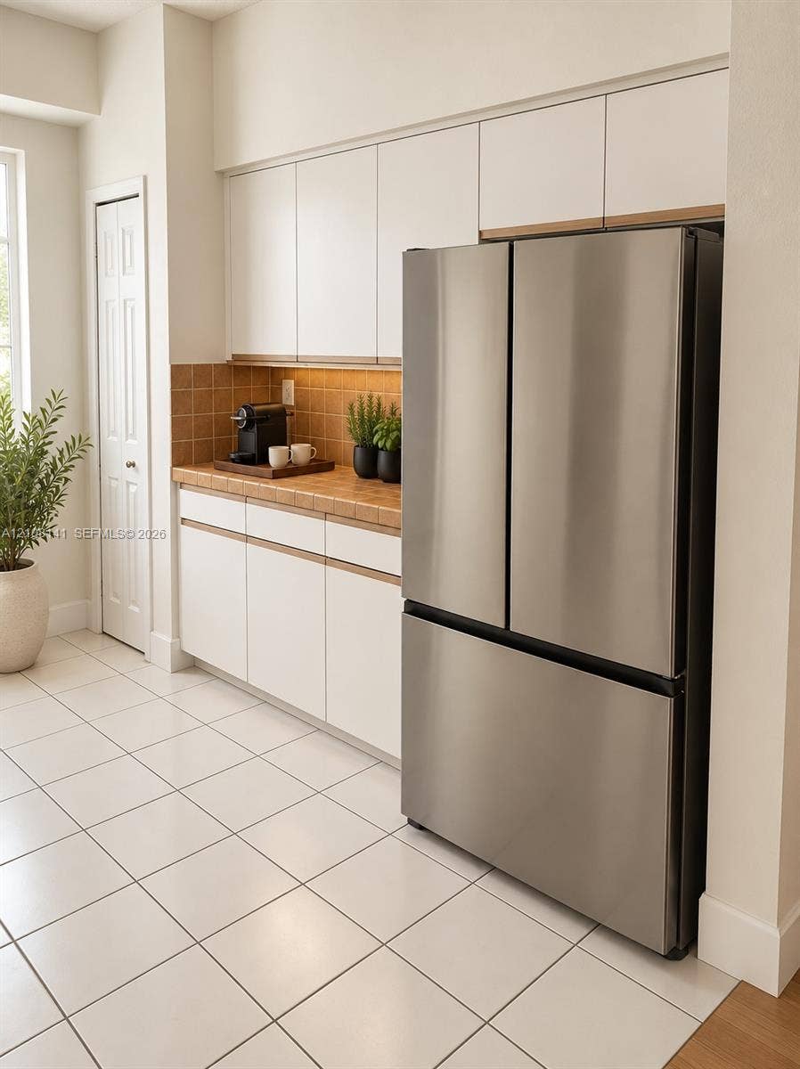 3135 NE 184th Street, #2205, Aventura, FL 33160 Kitchen area featuring white flat-panel cabinetry, a stainless steel French door refrigerator, tiled backsplash, and ceramic tile flooring