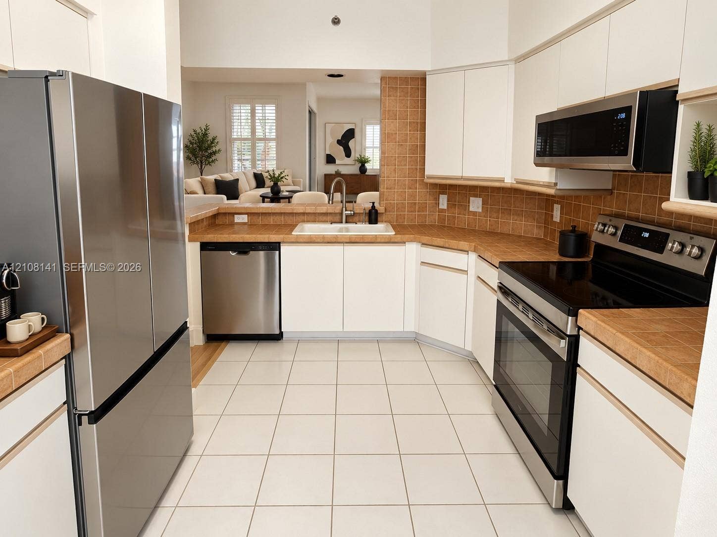 3135 NE 184th Street, #2205, Aventura, FL 33160 Kitchen featuring white cabinetry, tile countertops and backsplash, stainless steel appliances, and tile flooring