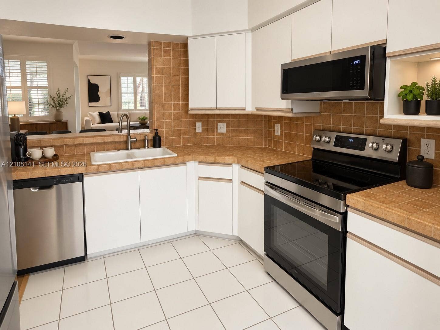 3135 NE 184th Street, #2205, Aventura, FL 33160 Kitchen featuring white cabinetry, stainless steel appliances, tile countertops, tile backsplash, and tile flooring