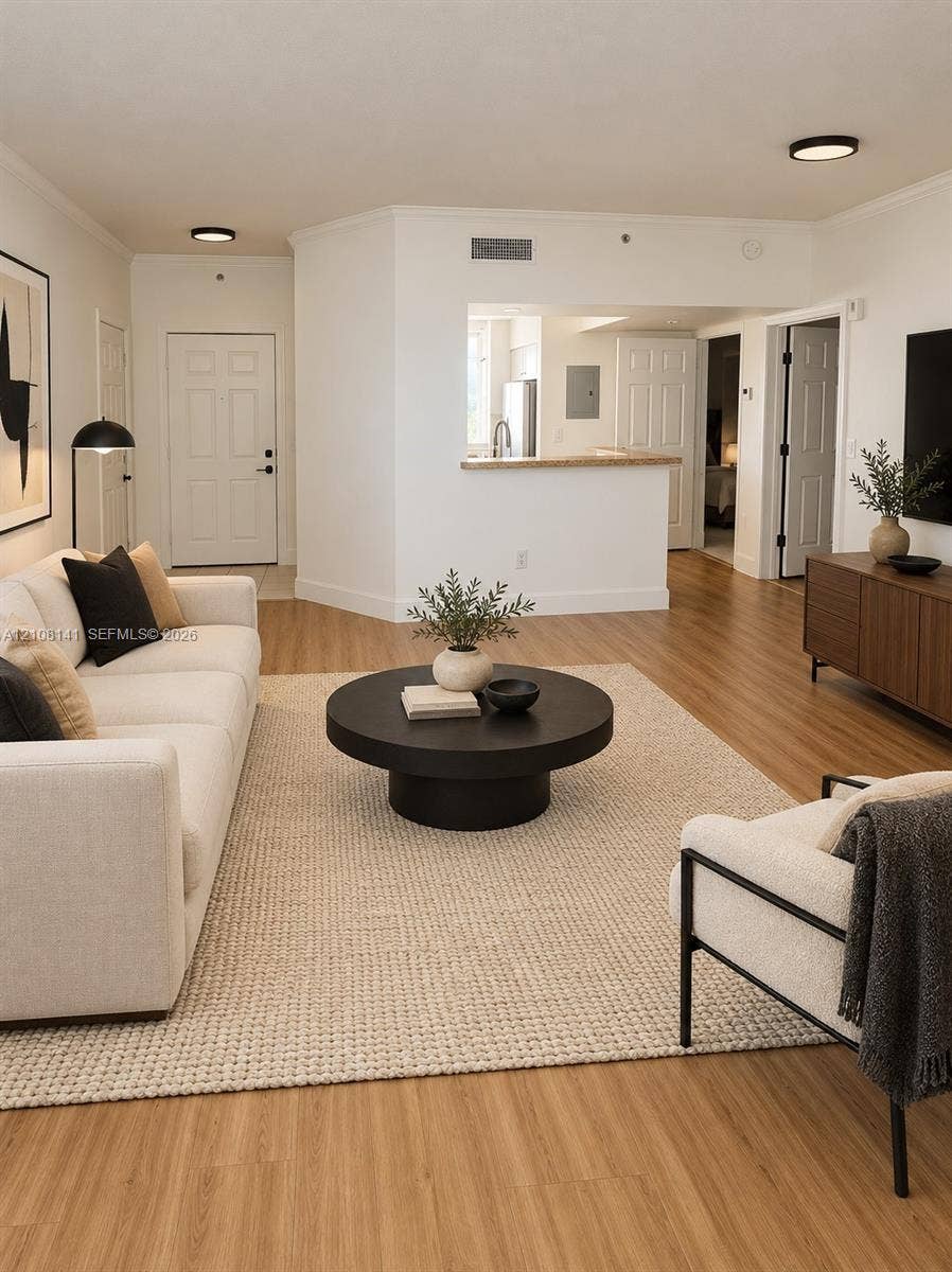 3135 NE 184th Street, #2205, Aventura, FL 33160 Living area featuring wood-finish flooring, recessed ceiling lighting, and a kitchen pass-through with a solid surface countertop