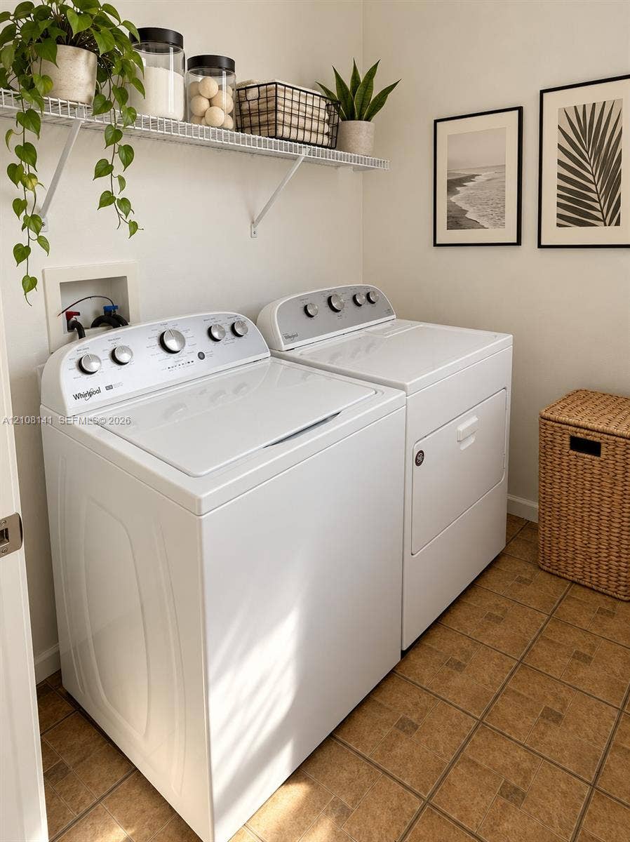 3135 NE 184th Street, #2205, Aventura, FL 33160 Laundry area featuring a top-loading washing machine, clothes dryer, wall-mounted wire shelving, and tiled flooring