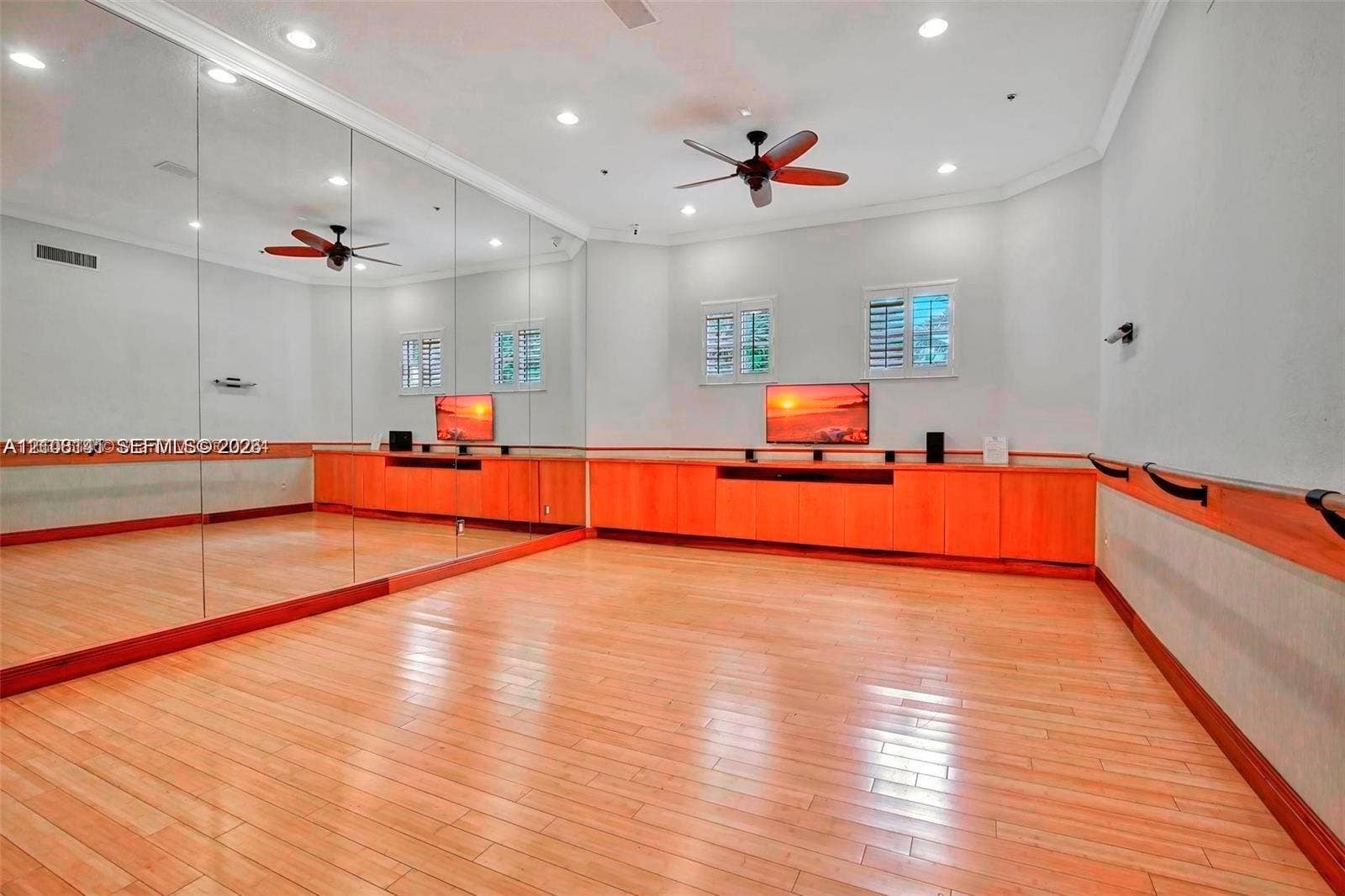 3135 NE 184th Street, #2205, Aventura, FL 33160 Full-length wall mirrors, light wood-finish flooring, custom built-in wood cabinetry, recessed lighting, and a wall-mounted ballet barre