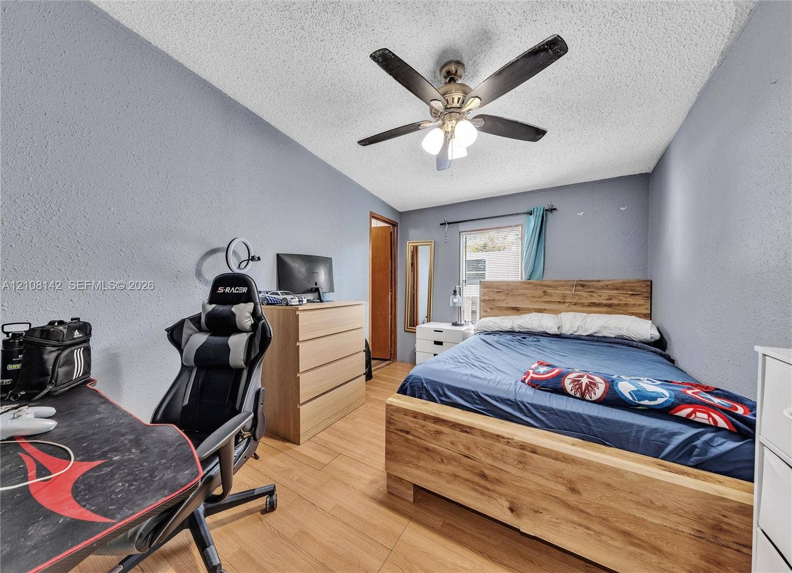 Wood-finish flooring, textured ceiling, and a ceiling fan with integrated lighting