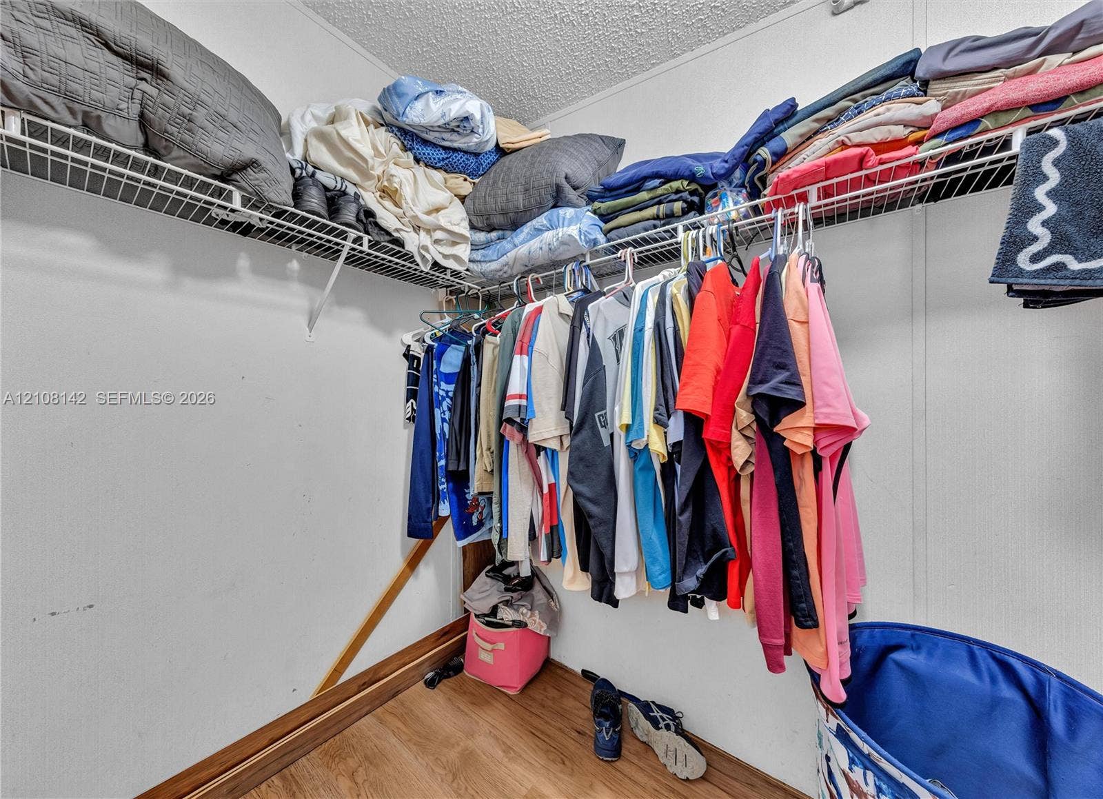 Storage area featuring wire shelving and wood-finish flooring