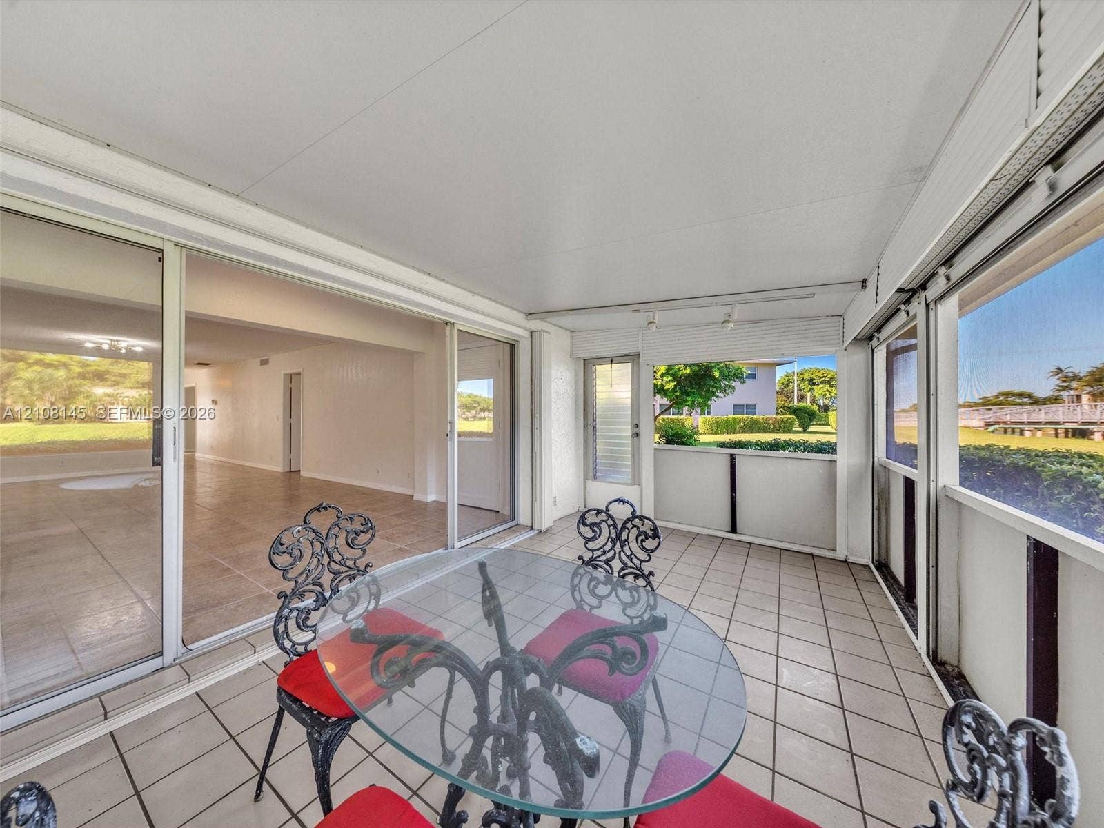 1020 Citrus Way, #101, Delray Beach, FL 33445 Enclosed patio featuring floor-to-ceiling screen panels, sliding glass door entry, and tiled flooring