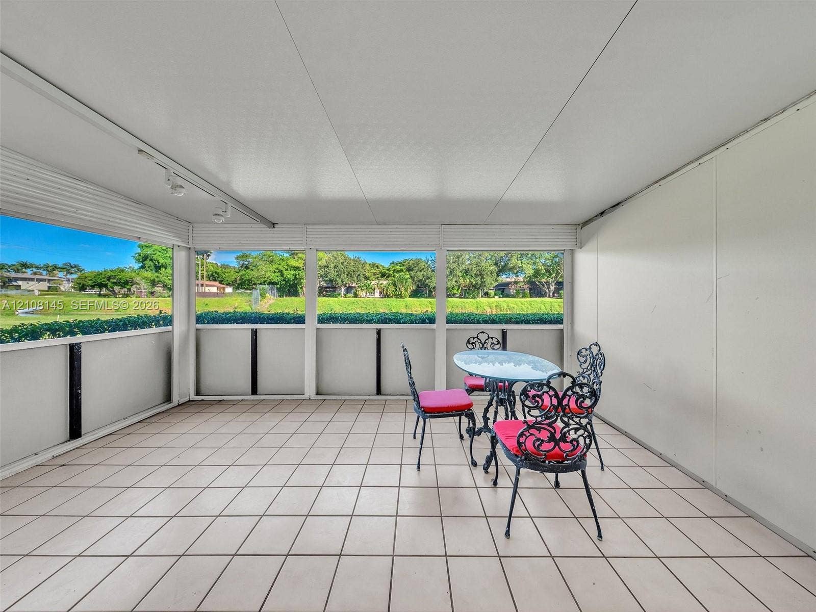 1020 Citrus Way, #101, Delray Beach, FL 33445 Enclosed patio featuring neutral tile flooring, screen wall panels, and overhead track lighting