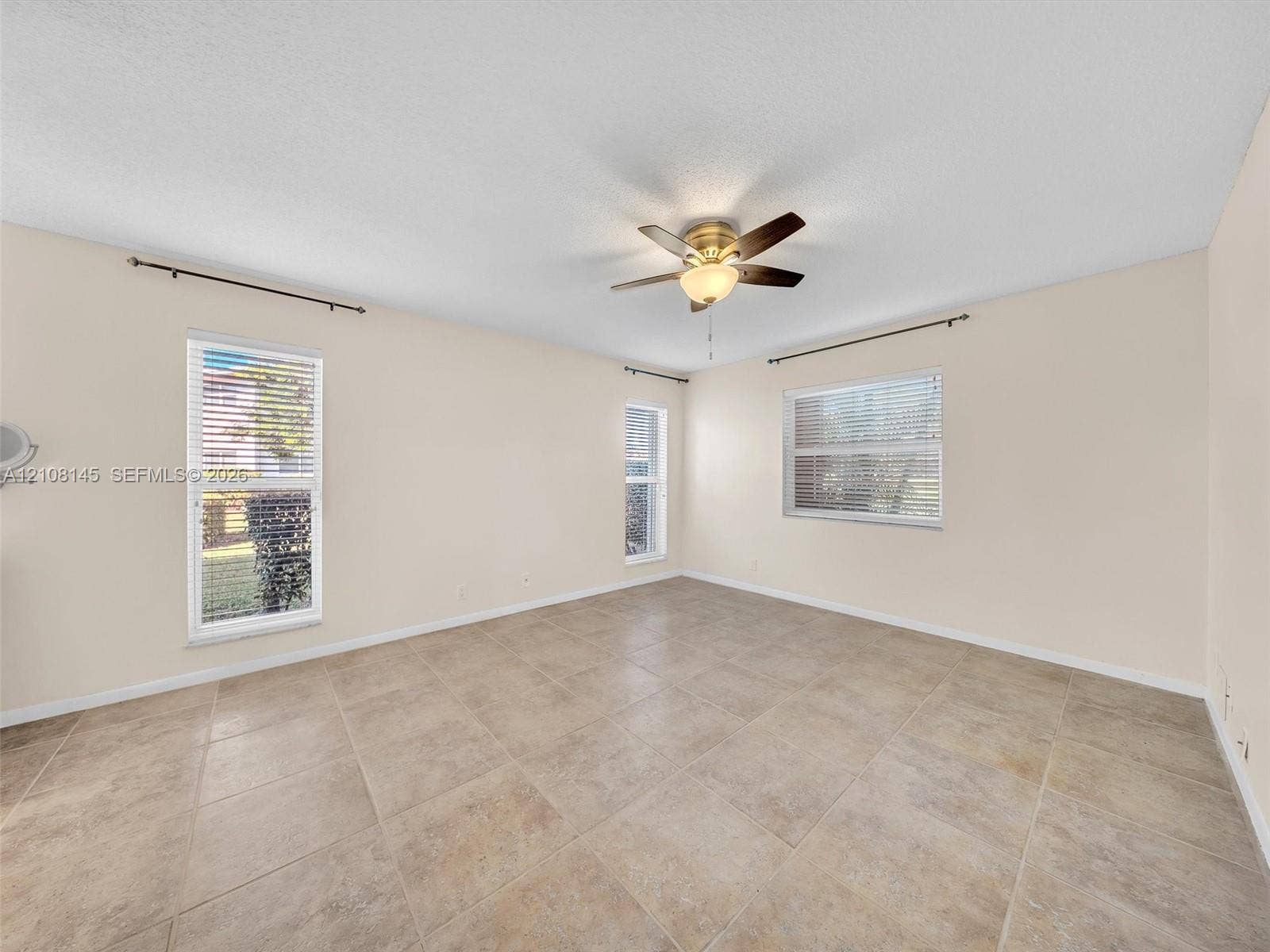 1020 Citrus Way, #101, Delray Beach, FL 33445 Neutral-toned tile flooring, multi-pane windows with horizontal blinds, and a central ceiling fan with integrated lighting