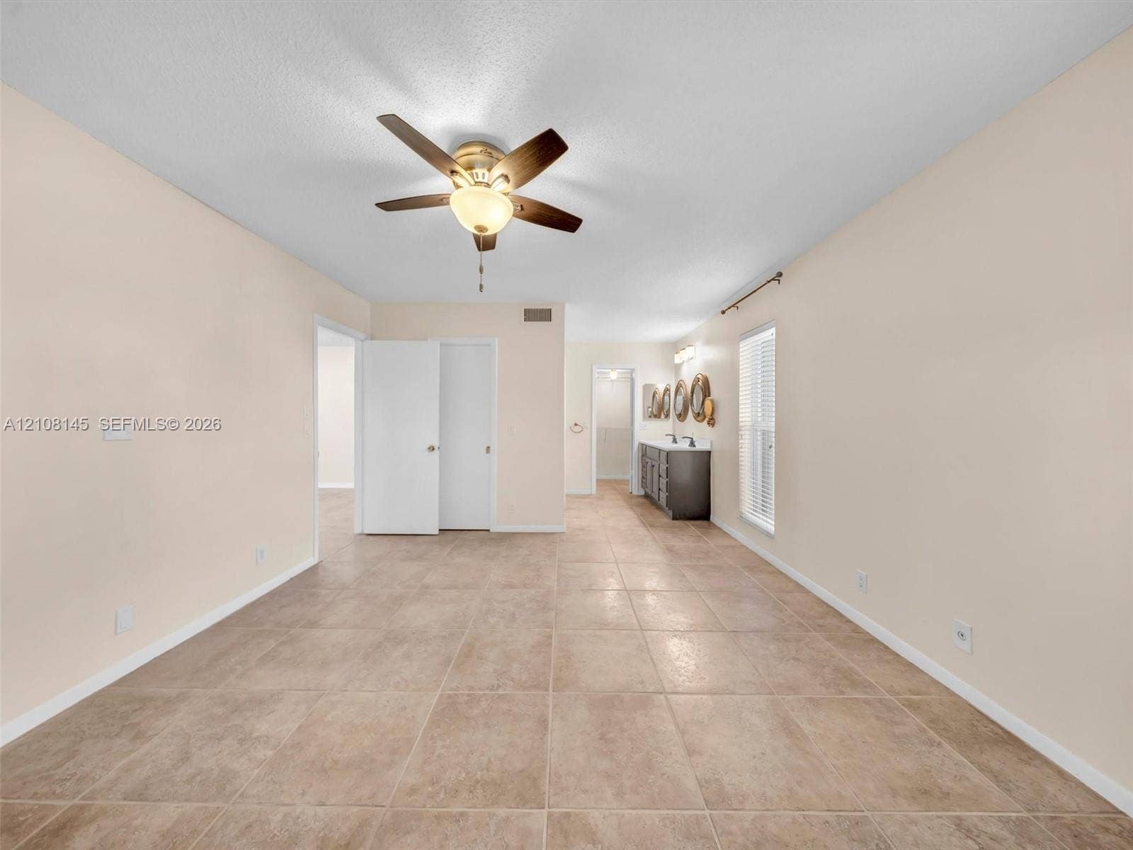 1020 Citrus Way, #101, Delray Beach, FL 33445 Large-format tile flooring, ceiling fan with integrated light fixture, dual-sink vanity with stone-surface countertop, and window blinds