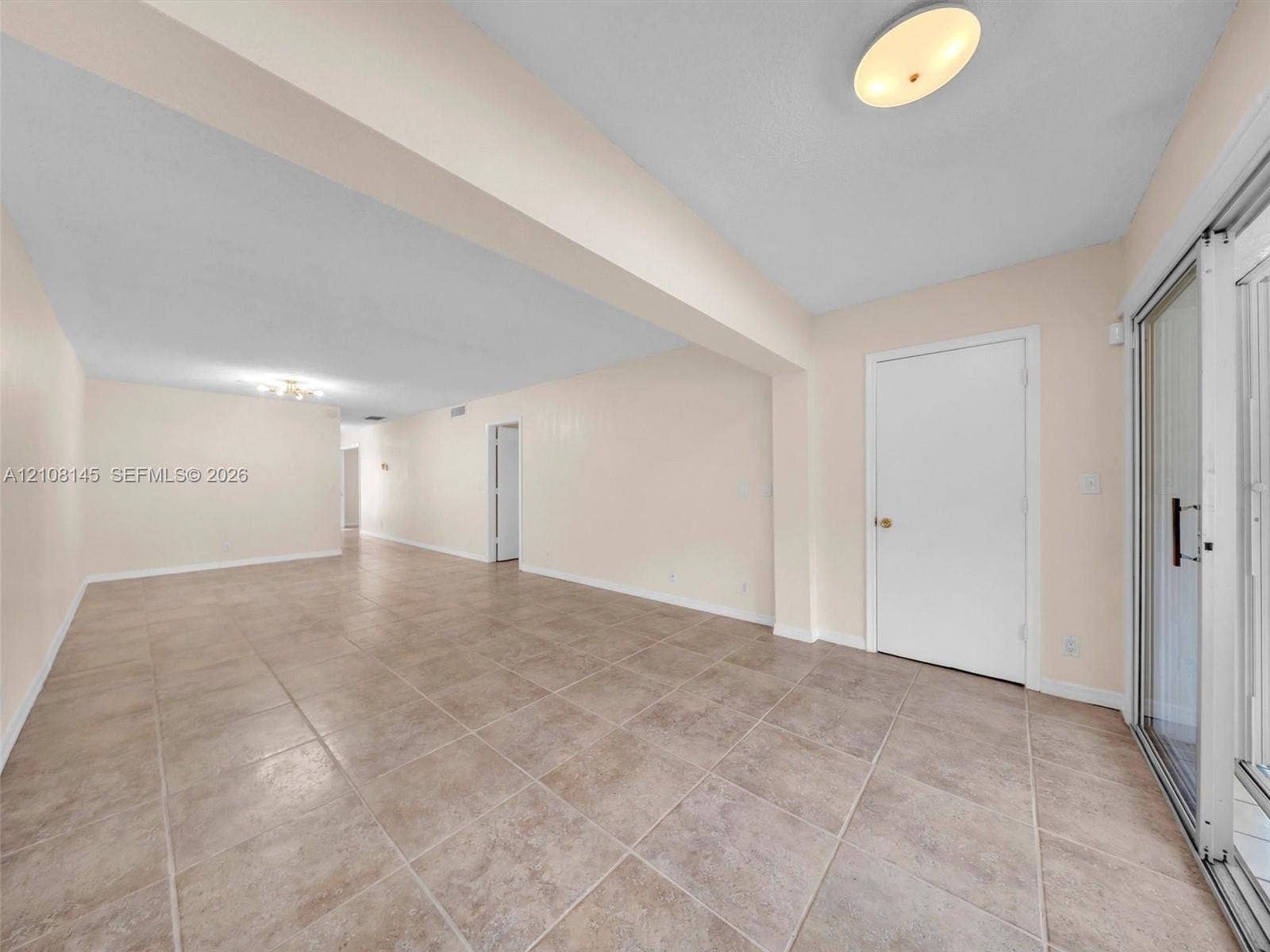 1020 Citrus Way, #101, Delray Beach, FL 33445 Neutral-toned tile flooring, recessed architectural beam, flush-mount ceiling lighting, and glass sliding door