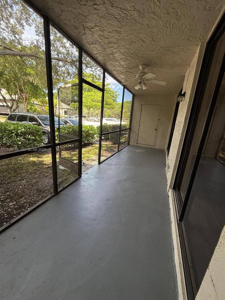 1258 S Military Trail, #813, Deerfield Beach, Deerfield Beach, FL 33442 Screened-in porch featuring a painted concrete floor, a textured ceiling, a ceiling fan, and black aluminum framing