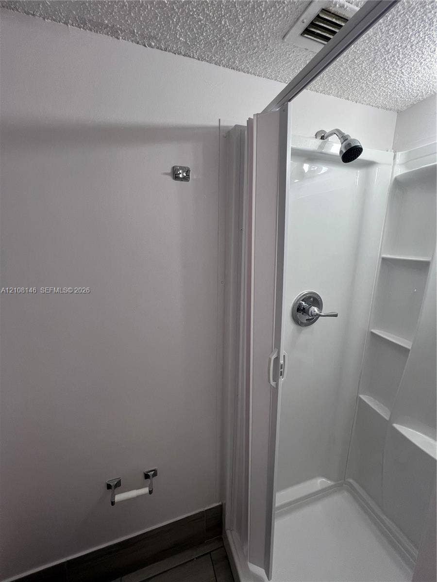 1258 S Military Trail, #813, Deerfield Beach, Deerfield Beach, FL 33442 Walk-in shower enclosure with integrated shelving, chrome-finish plumbing fixtures, and tiled flooring