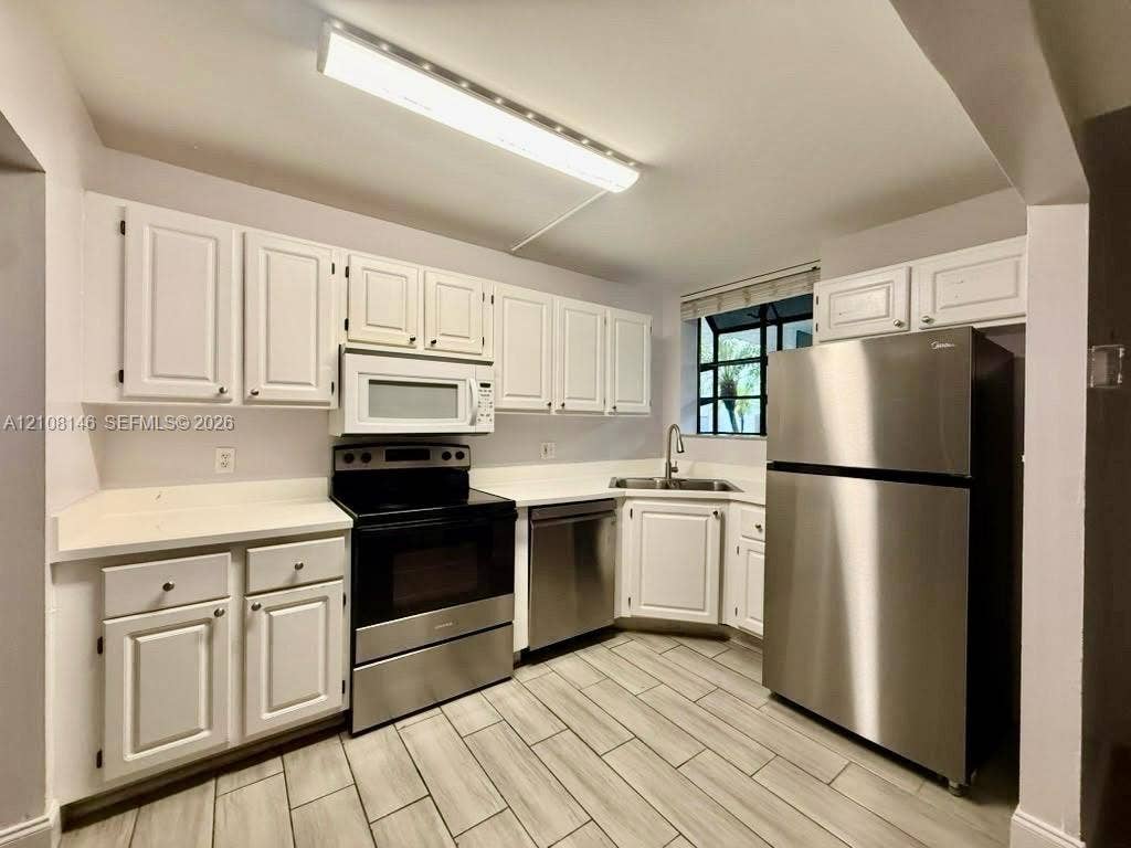 1258 S Military Trail, #813, Deerfield Beach, Deerfield Beach, FL 33442 Kitchen featuring white cabinetry, stone-surface countertops, stainless steel appliances, and tile flooring