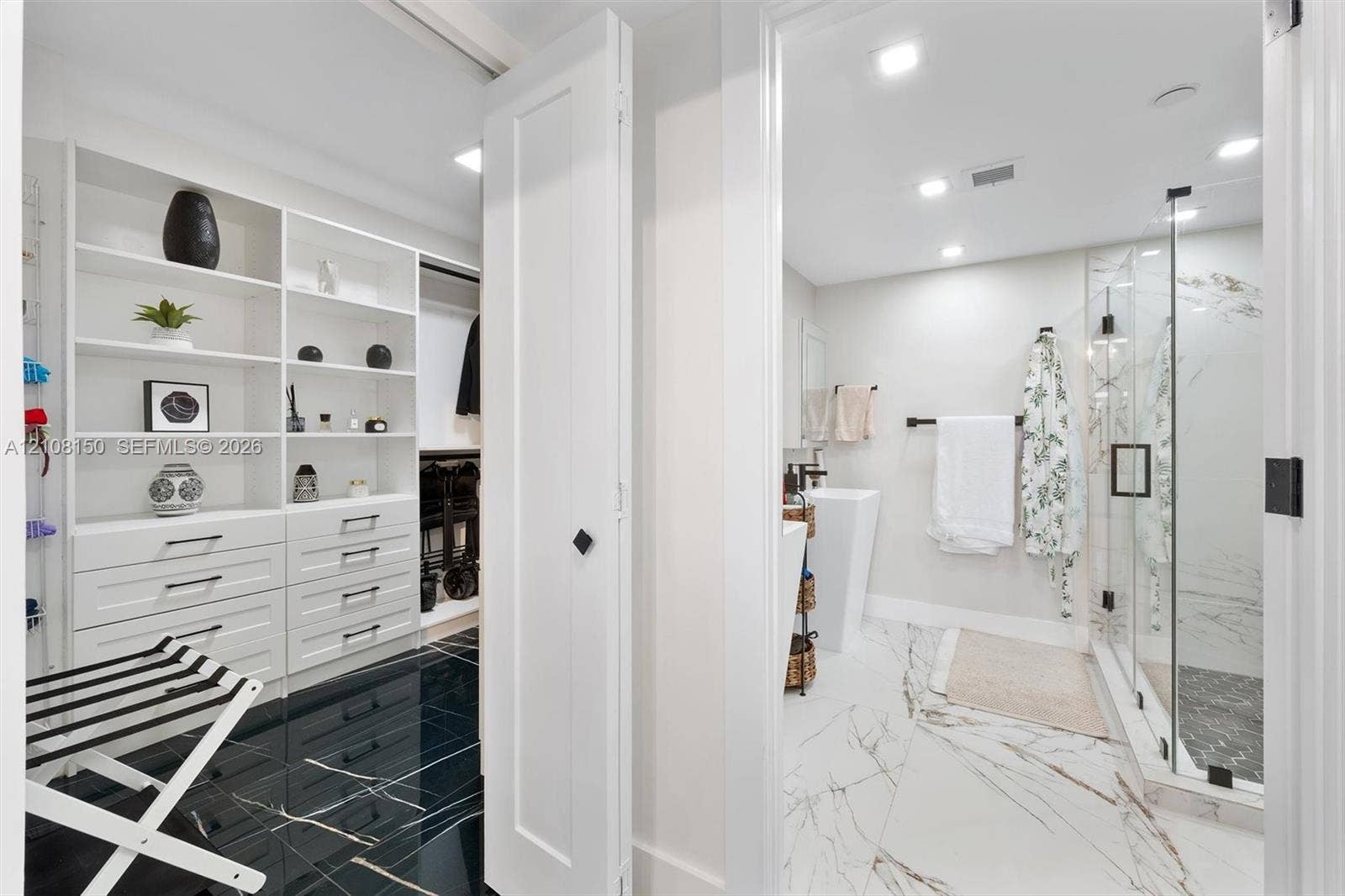 1000 Quayside Terrace, #709, Miami, Miami, FL 33138 Walk-in closet featuring white built-in shelving and drawer cabinetry, complemented by high-gloss dark stone-finish flooring
