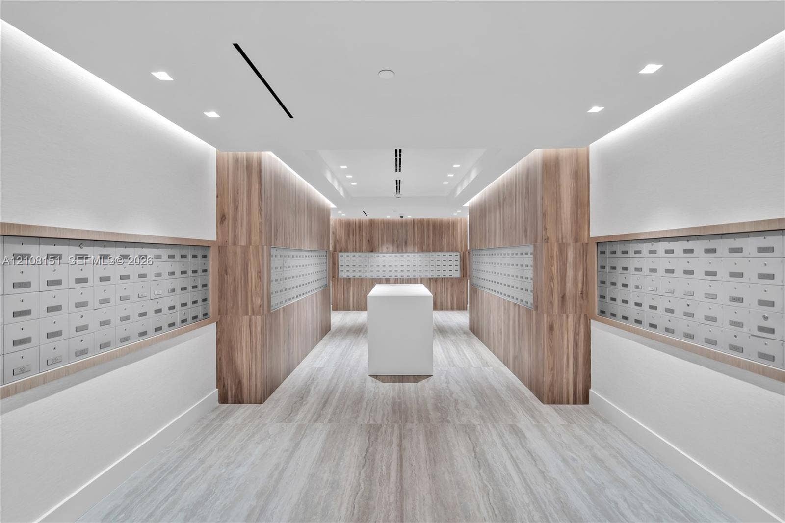 Mail center featuring wood-panel wall accents, recessed lighting, integrated wall-mounted mailboxes, stone-finish flooring, and a central white pedestal