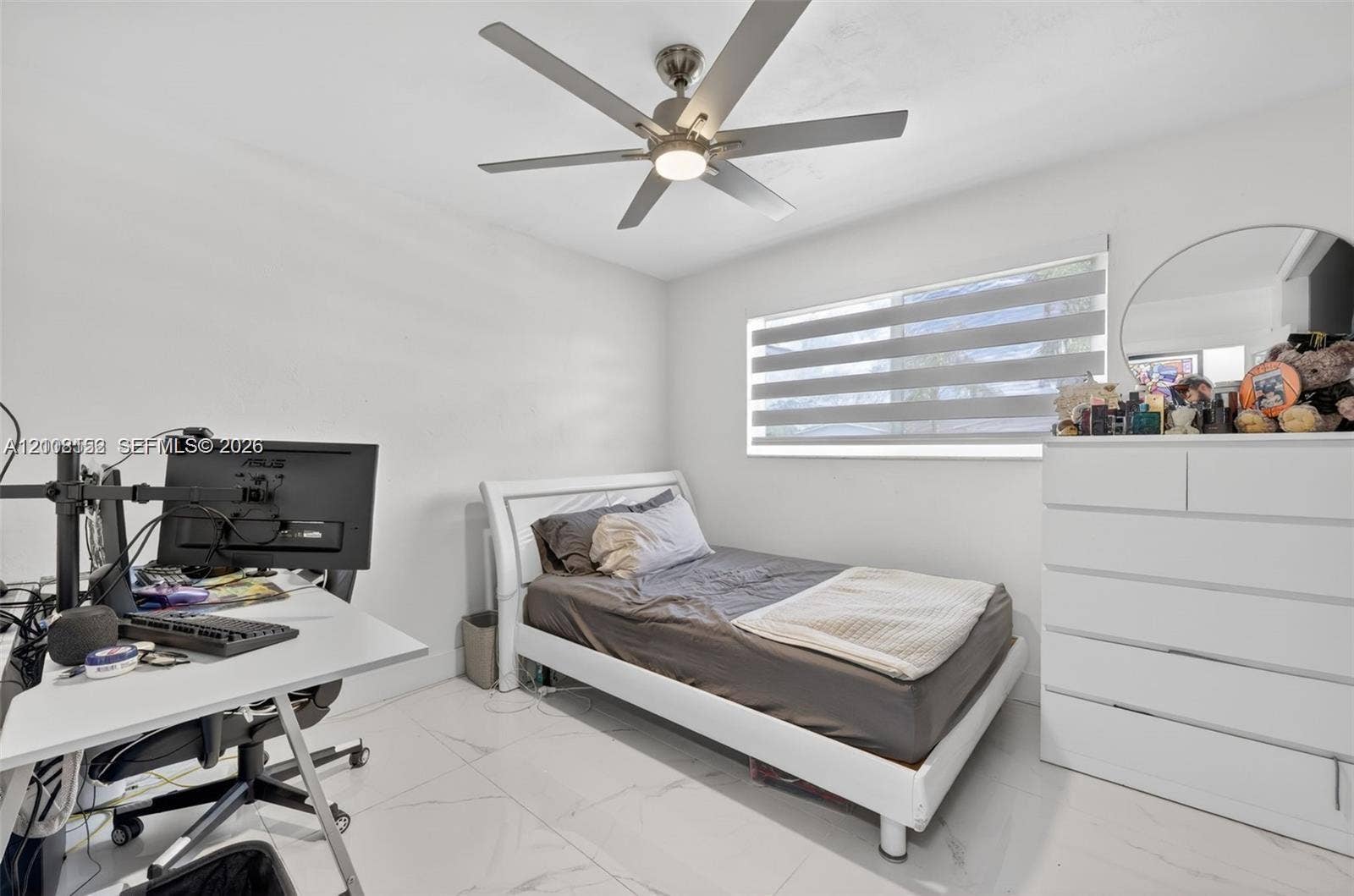 Neutral-toned room featuring large-format tile flooring, a multi-blade ceiling fan with integrated lighting, and horizontal window blinds