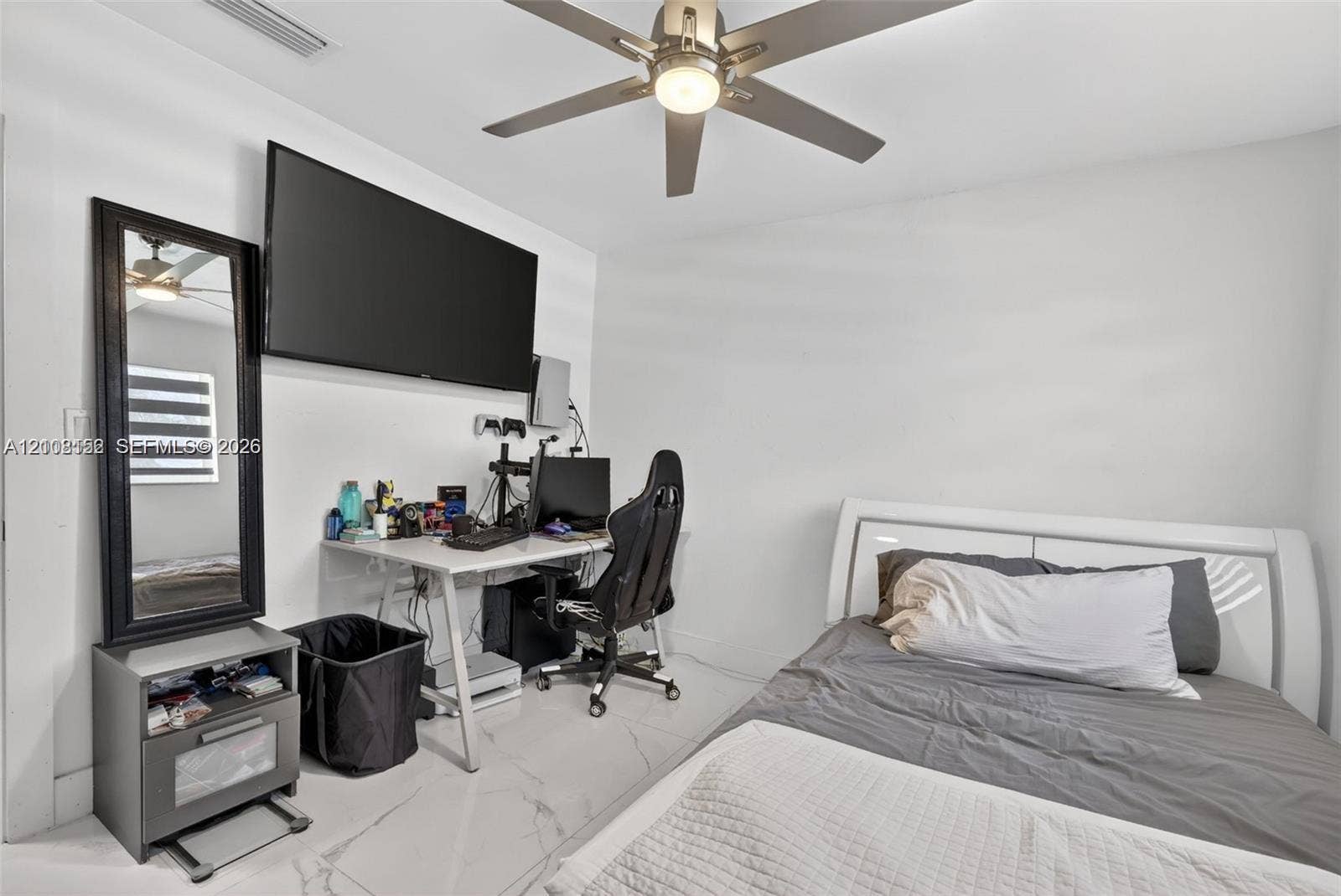Interior space featuring white stone-finish flooring, a wall-mounted ceiling fan with integrated lighting, and neutral wall tones