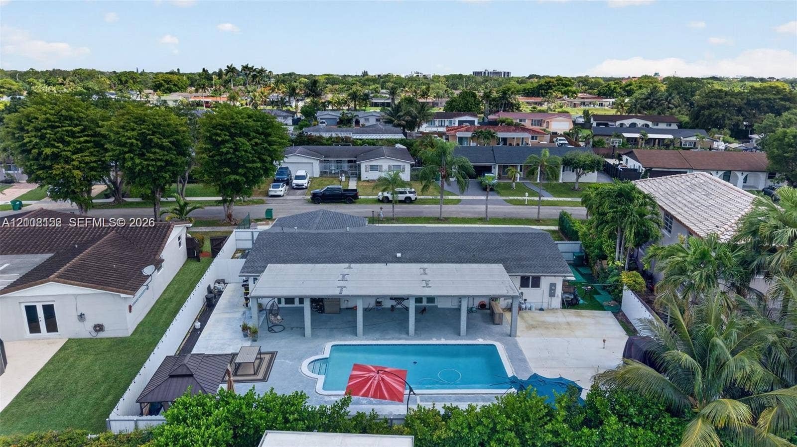 Concrete patio, covered lanai, private swimming pool, privacy fencing, and mature landscaping