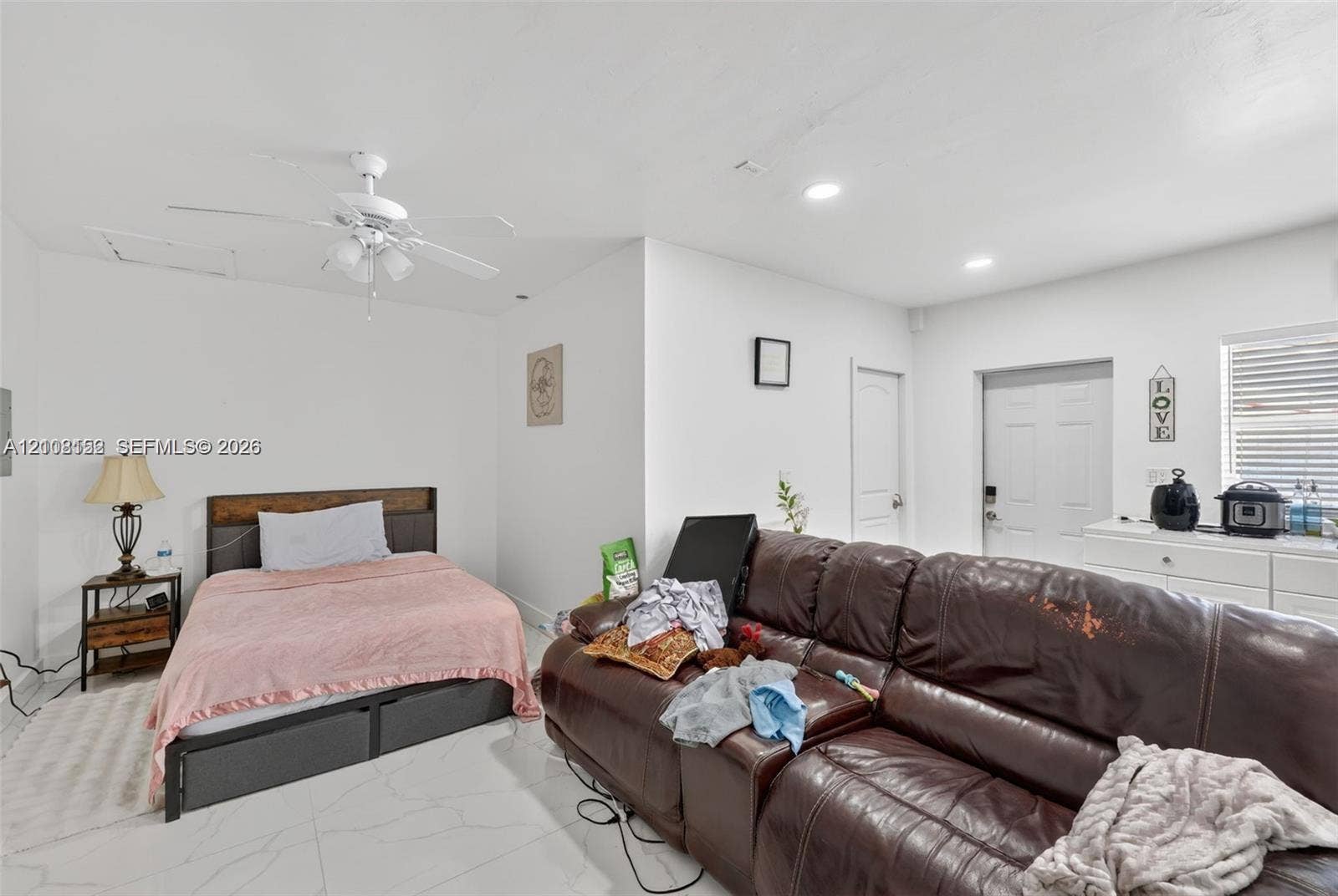 Spacious interior featuring white tile flooring, recessed lighting, and a white ceiling fan with integrated lighting