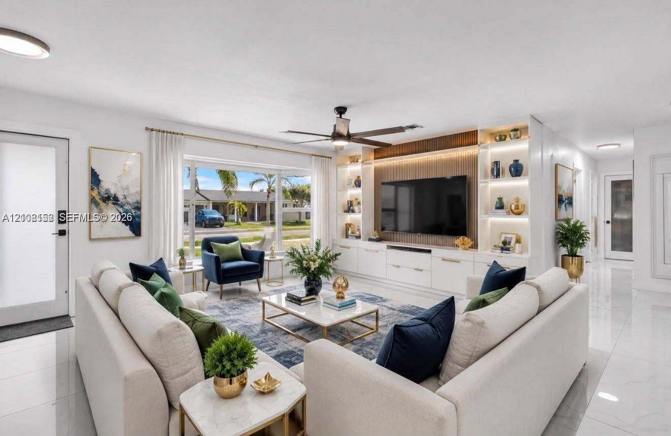 Large living area featuring polished tile flooring, expansive bay window, and custom floor-to-ceiling built-in cabinetry with integrated accent lighting and wood-slat paneling