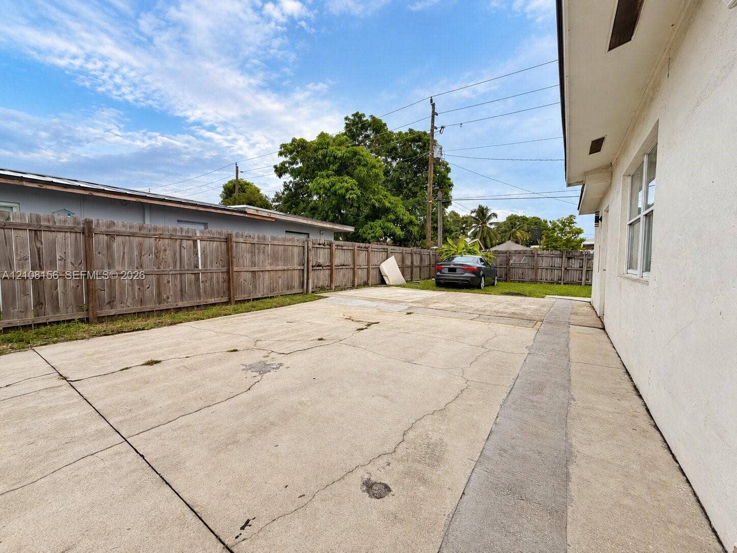 17175 NW 41st Avenue, Miami Gardens, FL 33055 Exterior concrete driveway featuring a wood-panel perimeter fence