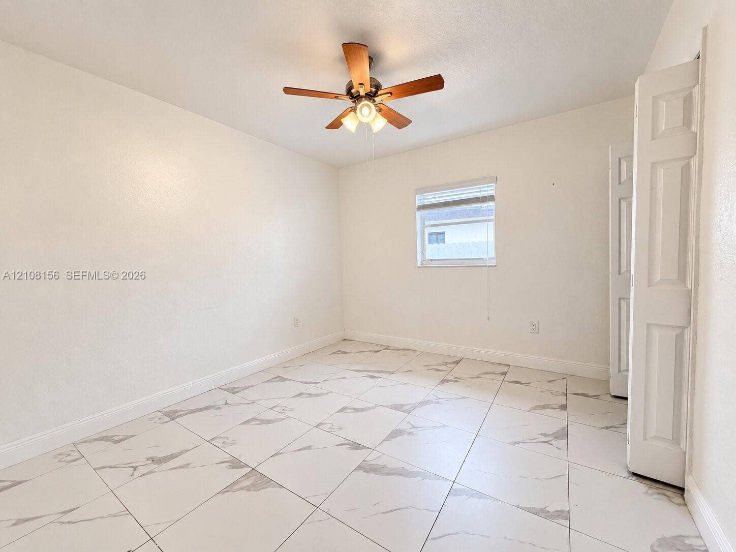17175 NW 41st Avenue, Miami Gardens, FL 33055 Interior room featuring large-format tile flooring with a neutral pattern, high-contrast ceiling fan with integrated lighting, and white six-panel closet doors
