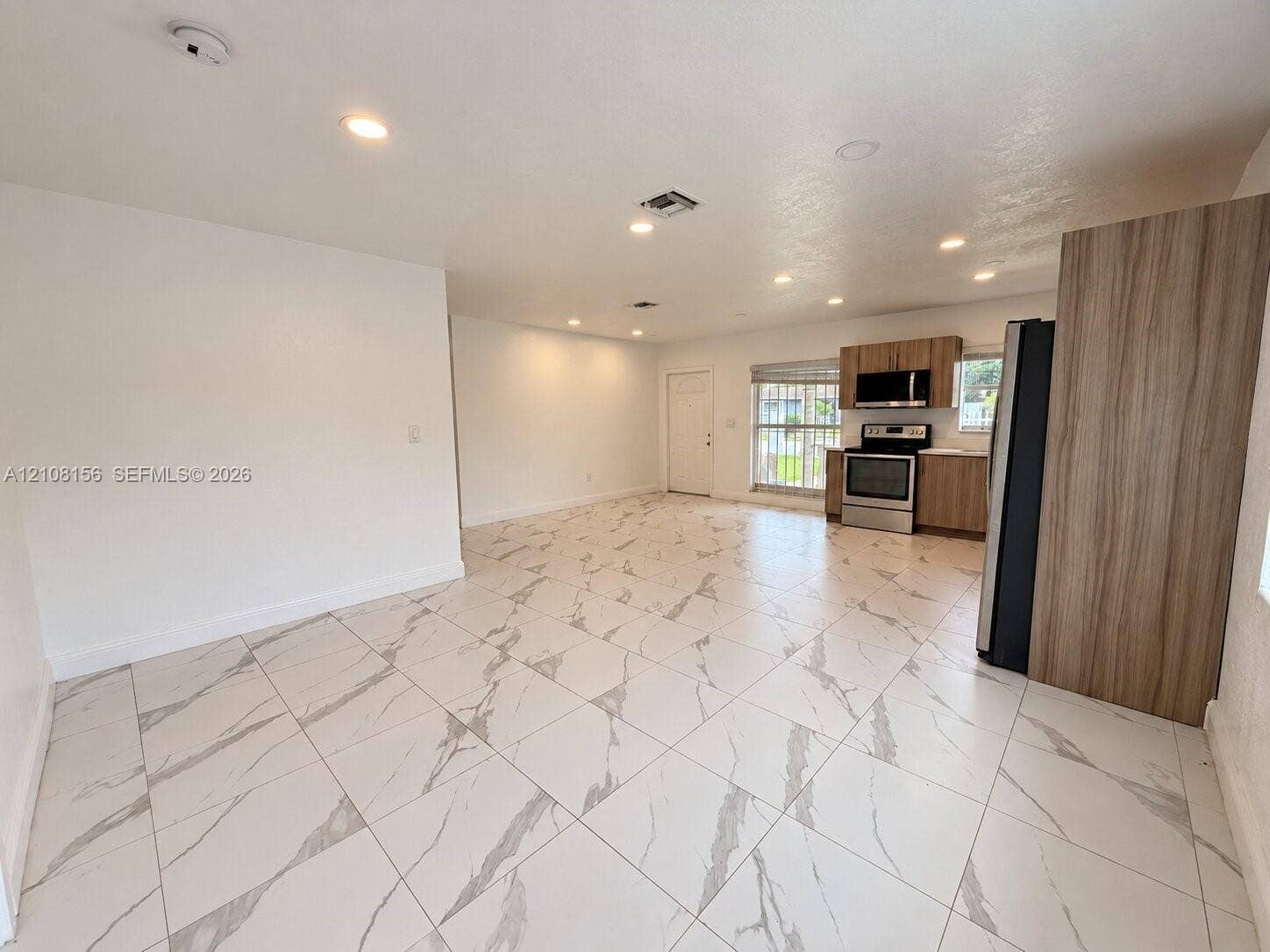 17175 NW 41st Avenue, Miami Gardens, FL 33055 Large-format stone-style tile flooring, recessed lighting, wood-finish cabinetry, stainless steel kitchen appliances, and neutral wall tones