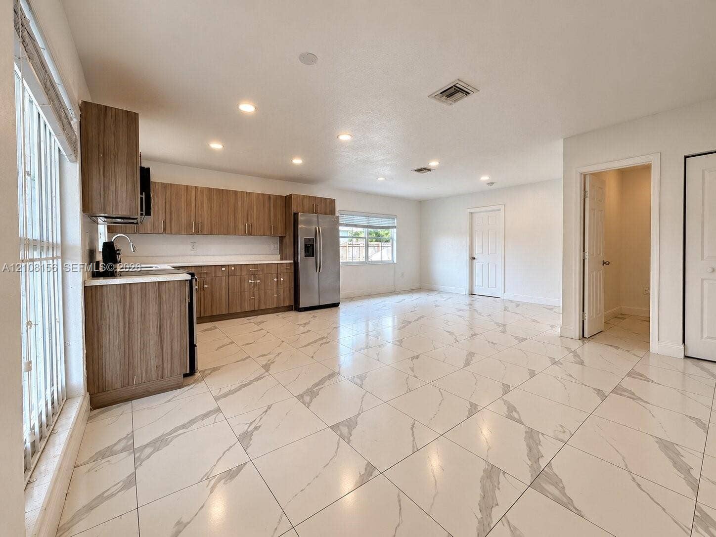 17175 NW 41st Avenue, Miami Gardens, FL 33055 Kitchen featuring wood-finish cabinetry, stainless steel refrigerator, white countertops, recessed lighting, and large-format porcelain tile flooring