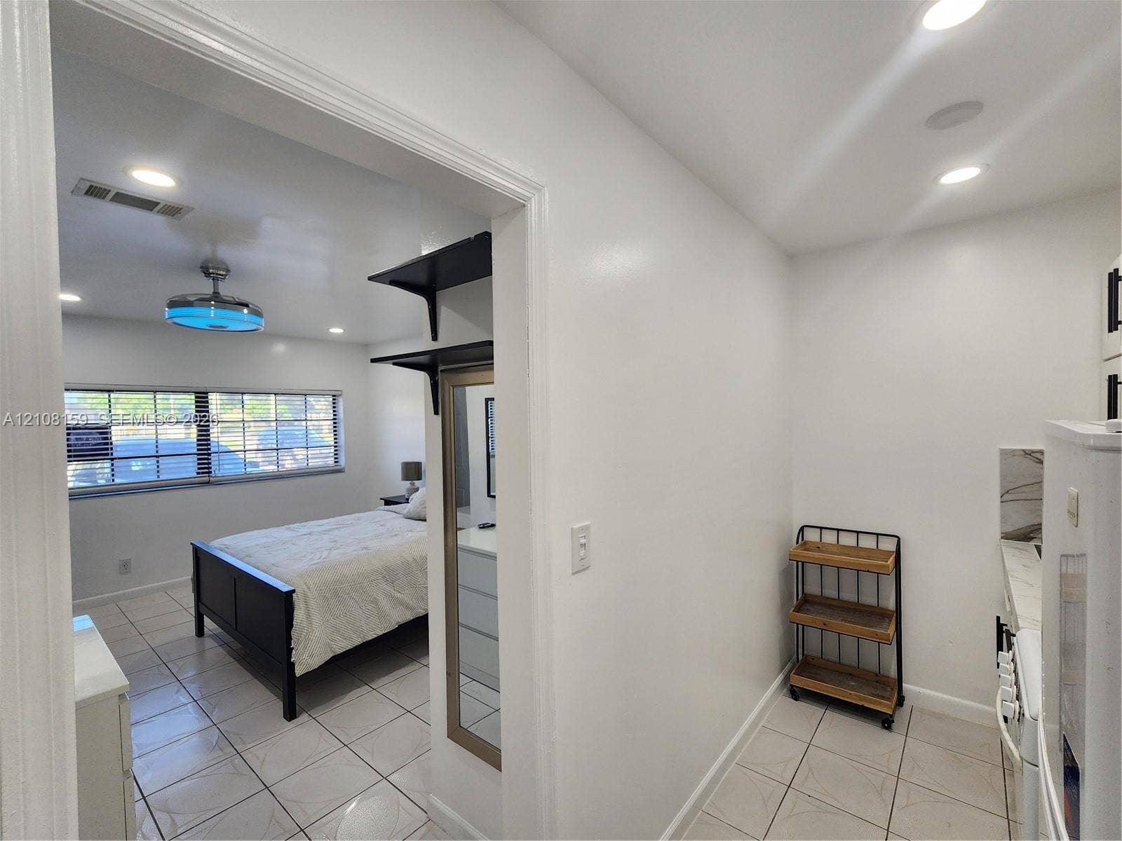 Ceramic tile flooring throughout, recessed ceiling lighting, multi-pane windows, and built-in wall shelving
