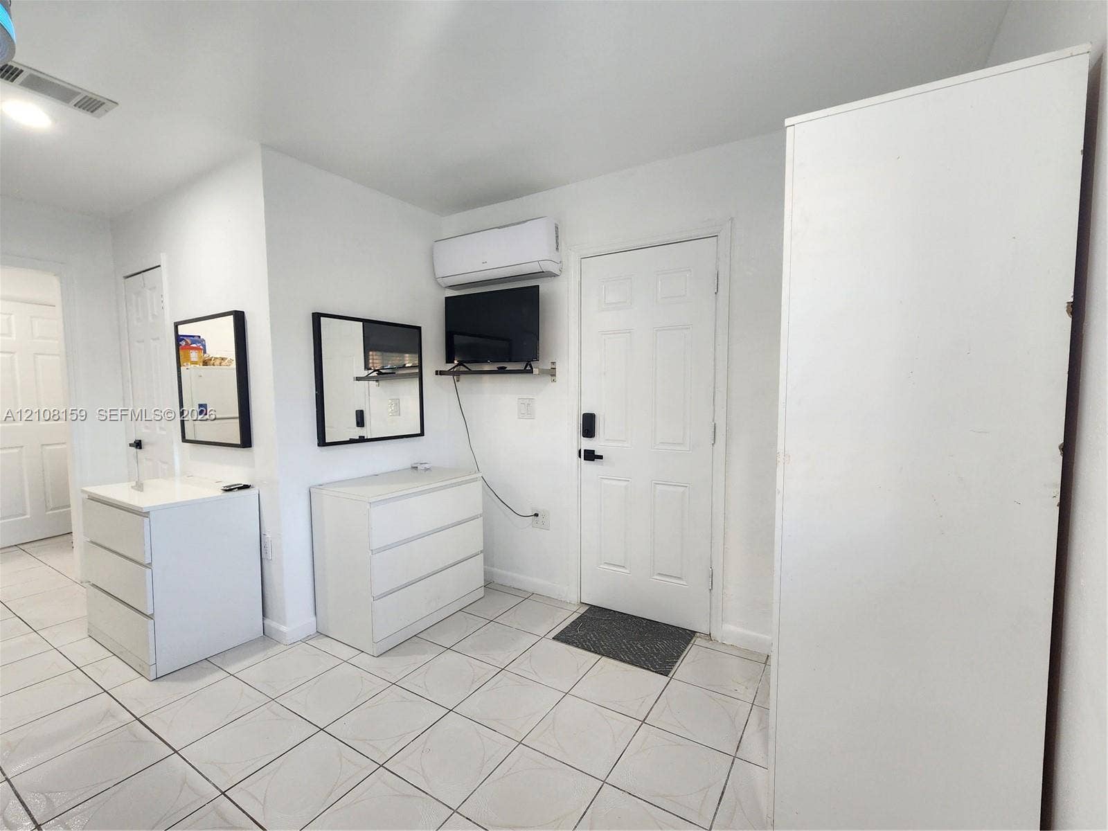 Ceramic tile flooring throughout and wall-mounted ductless air conditioning unit