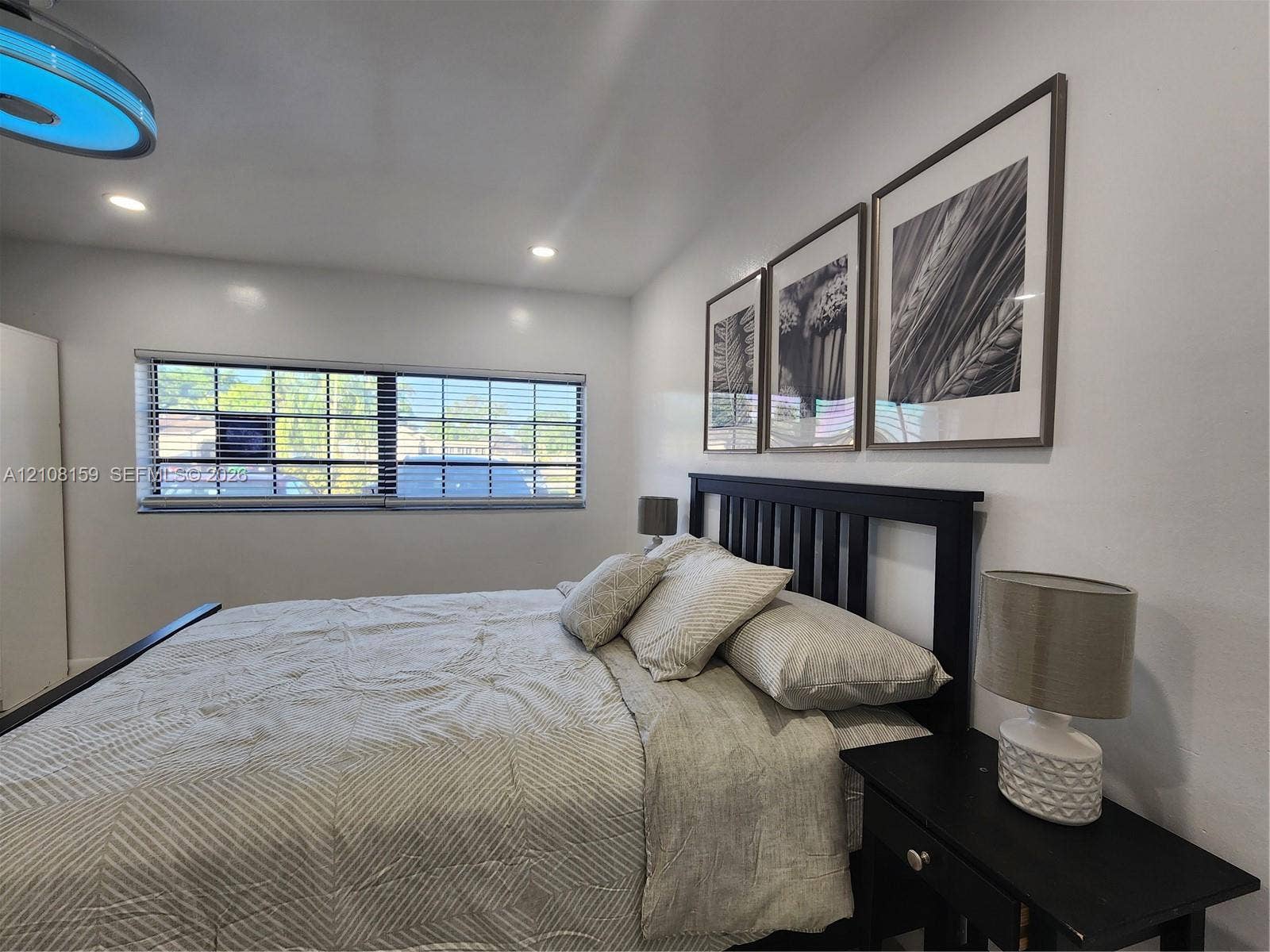 Recessed ceiling lighting, wide horizontal window with integrated blinds, and smooth-finish walls