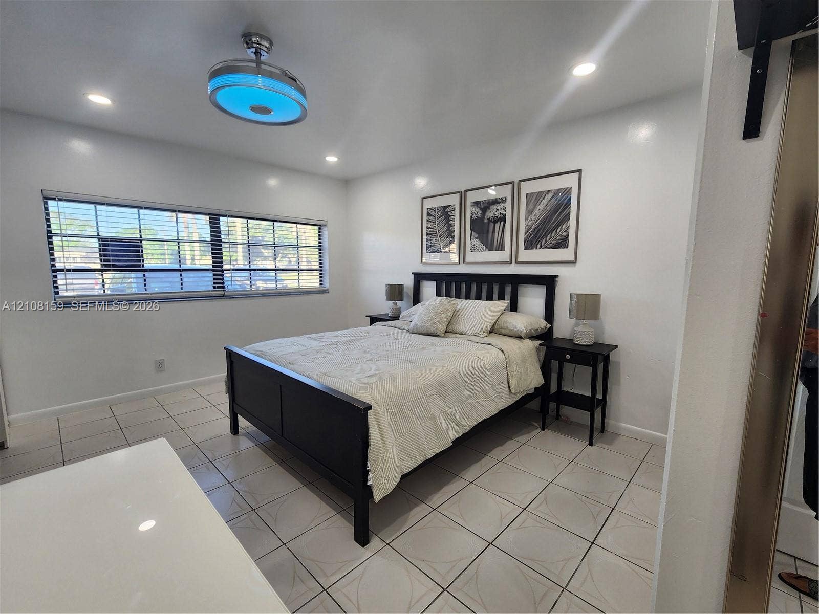 Ceramic tile flooring, recessed lighting, and a modern circular ceiling fan fixture with integrated lighting