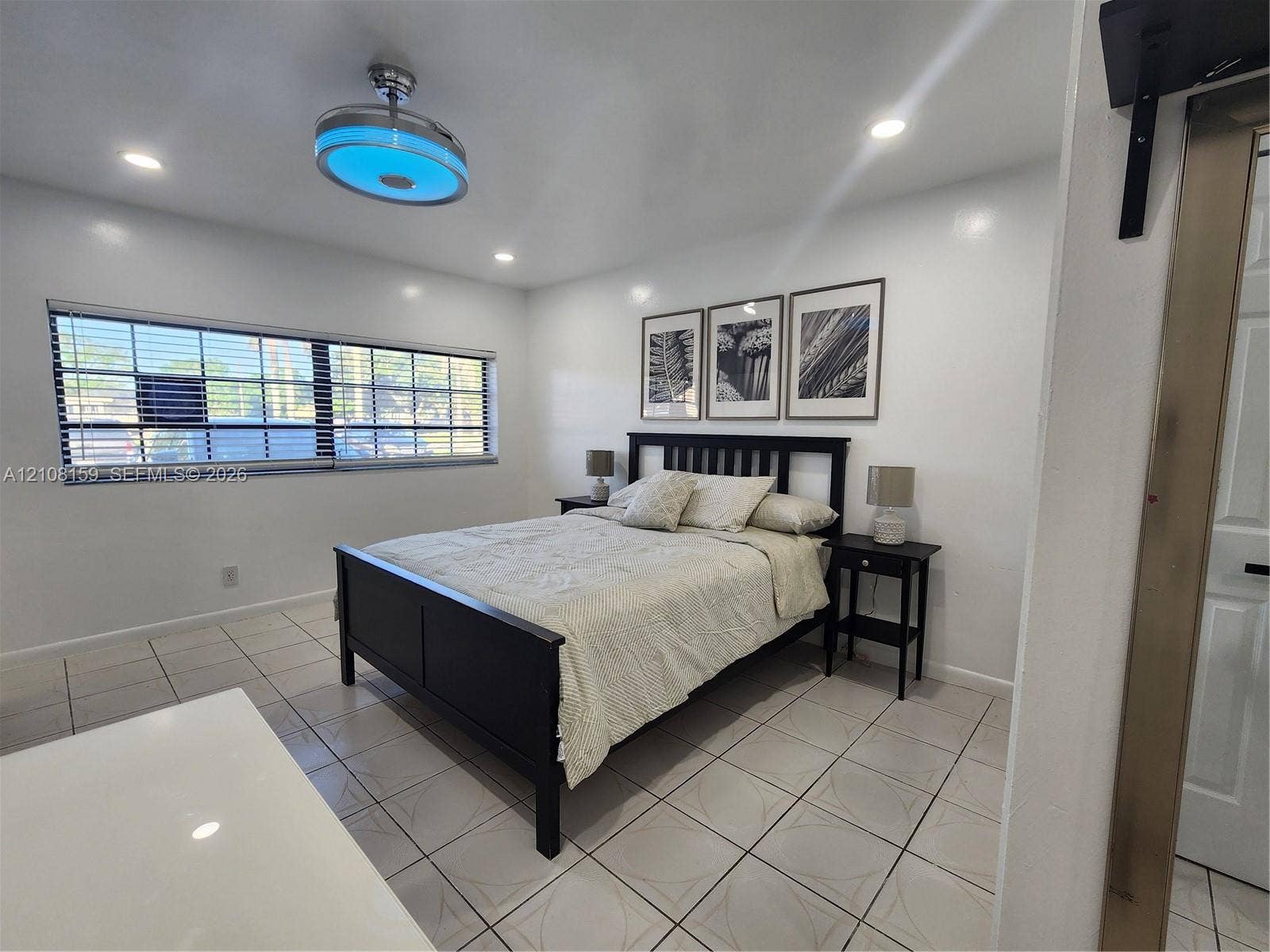 Ceramic tile flooring, recessed lighting, and a contemporary ceiling fan with integrated lighting