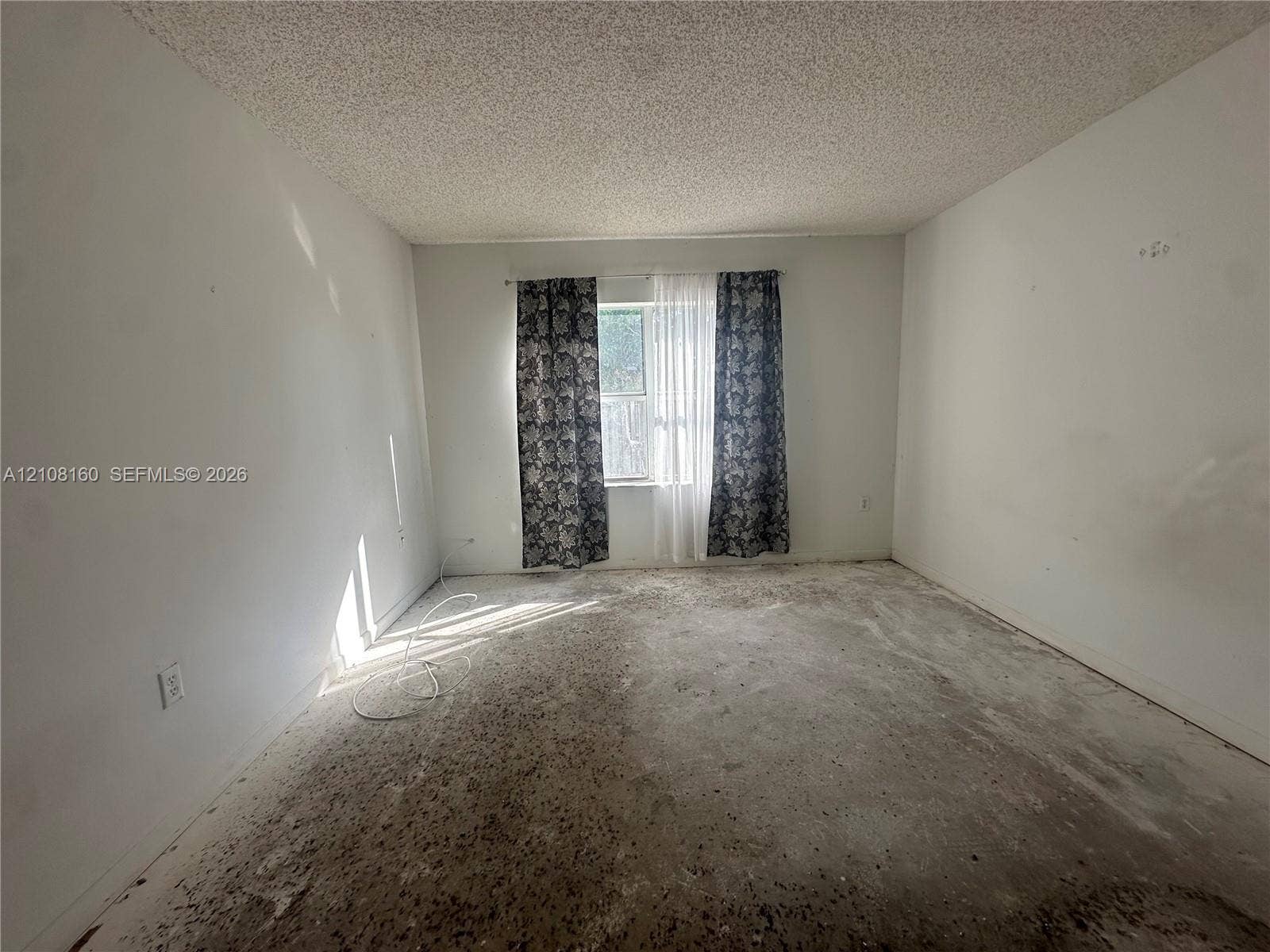1262 NW 126th Avenue, Sunrise, FL 33323 Interior space featuring a single-pane window with a horizontal orientation, white walls, and a textured ceiling finish