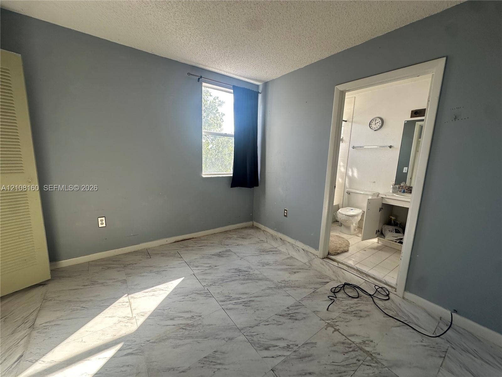 1262 NW 126th Avenue, Sunrise, FL 33323 Large-format tile flooring, louvered-panel closet door, and single-pane window with natural lighting