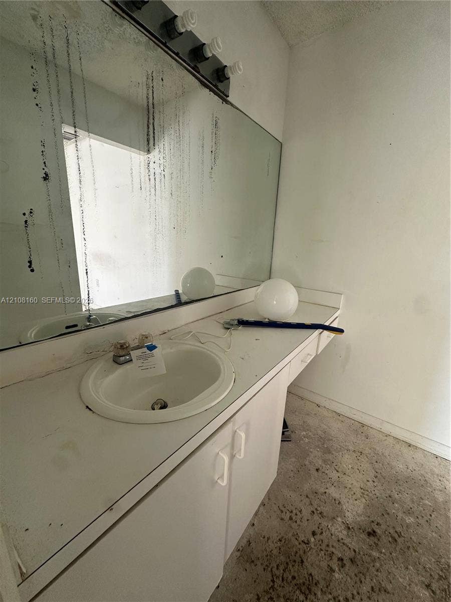 1262 NW 126th Avenue, Sunrise, FL 33323 Vanity featuring an integrated white sink, countertop, and lower cabinetry with hardware