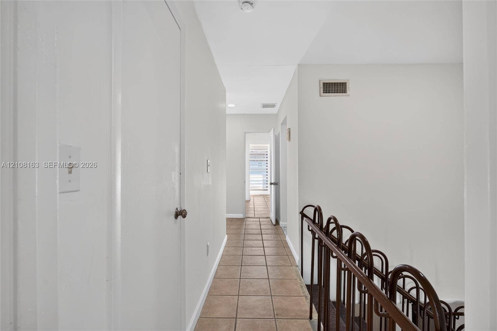 11510 SW 5th Street, #1, Sweetwater, Sweetwater, FL 33174 Hallway featuring neutral tile flooring and a decorative metal stair railing