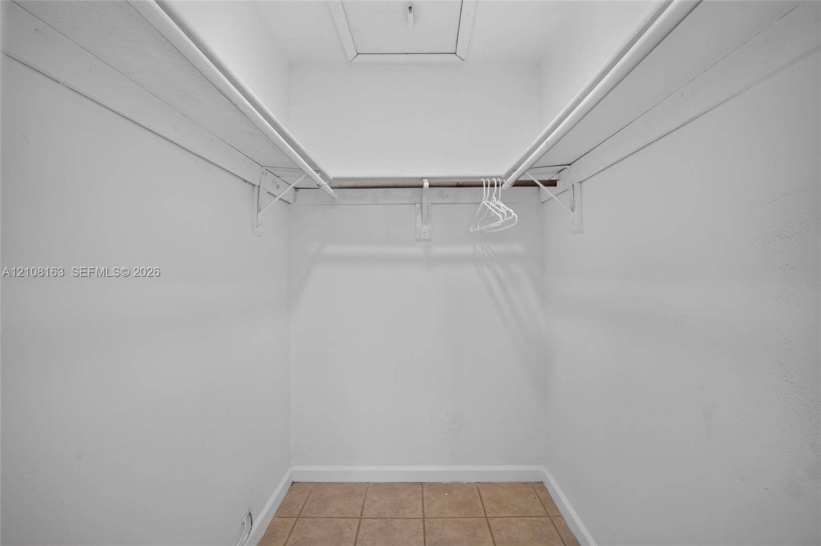 11510 SW 5th Street, #1, Sweetwater, Sweetwater, FL 33174 Storage area featuring neutral tile flooring, white interior walls, and dual-level wall-mounted shelving rods