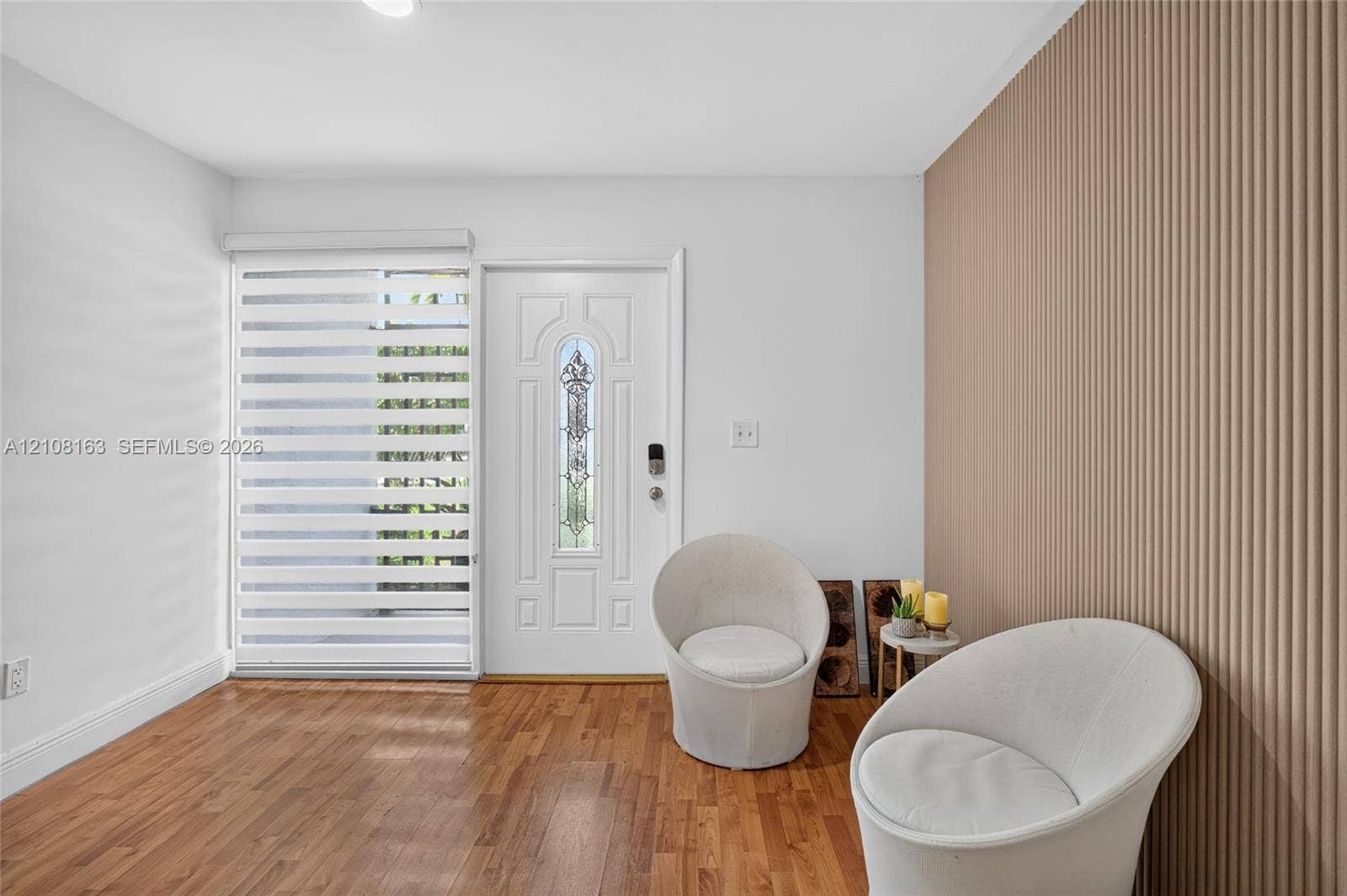 11510 SW 5th Street, #1, Sweetwater, Sweetwater, FL 33174 Entry featuring wood-finish flooring, a decorative textured wall treatment, a panel door with a decorative glass insert, and adjustable horizontal window treatments