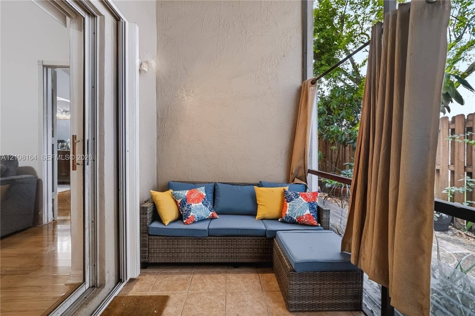 3983 NW 122nd Terrace, Sunrise, FL 33323 Covered patio featuring ceramic tile flooring, textured stucco wall, and metal-framed screen enclosure