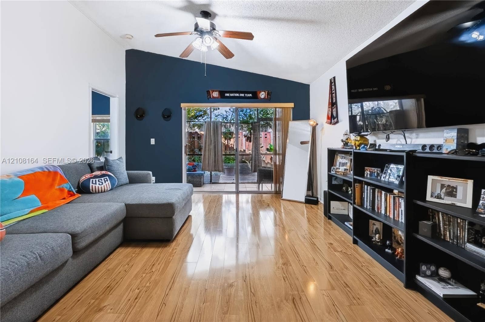 3983 NW 122nd Terrace, Sunrise, FL 33323 Vaulted ceilings, wood-finish flooring, accent wall, and sliding glass doors