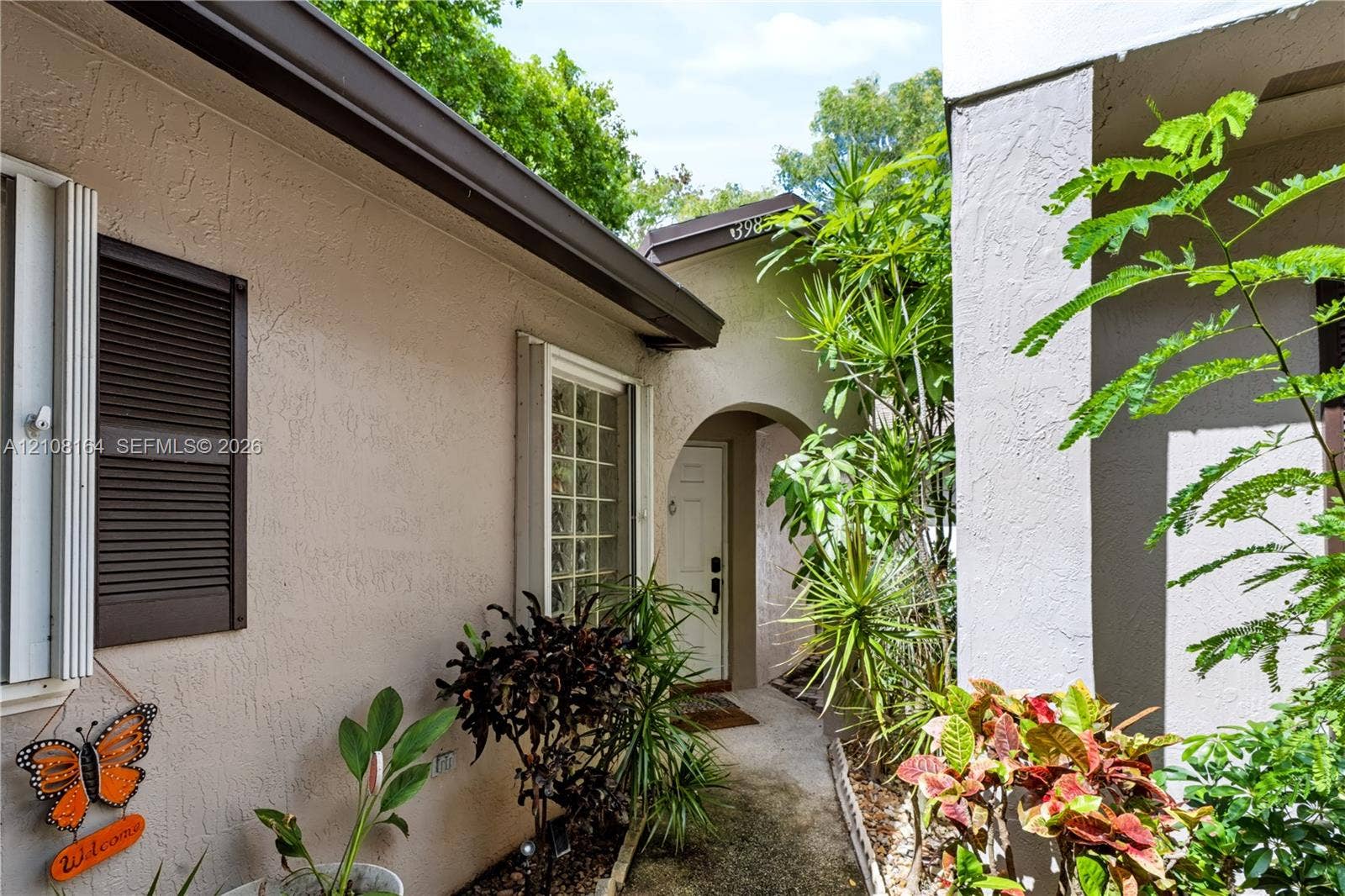 3983 NW 122nd Terrace, Sunrise, FL 33323 Stucco exterior featuring arched entry, decorative window shutters, and a recessed front door