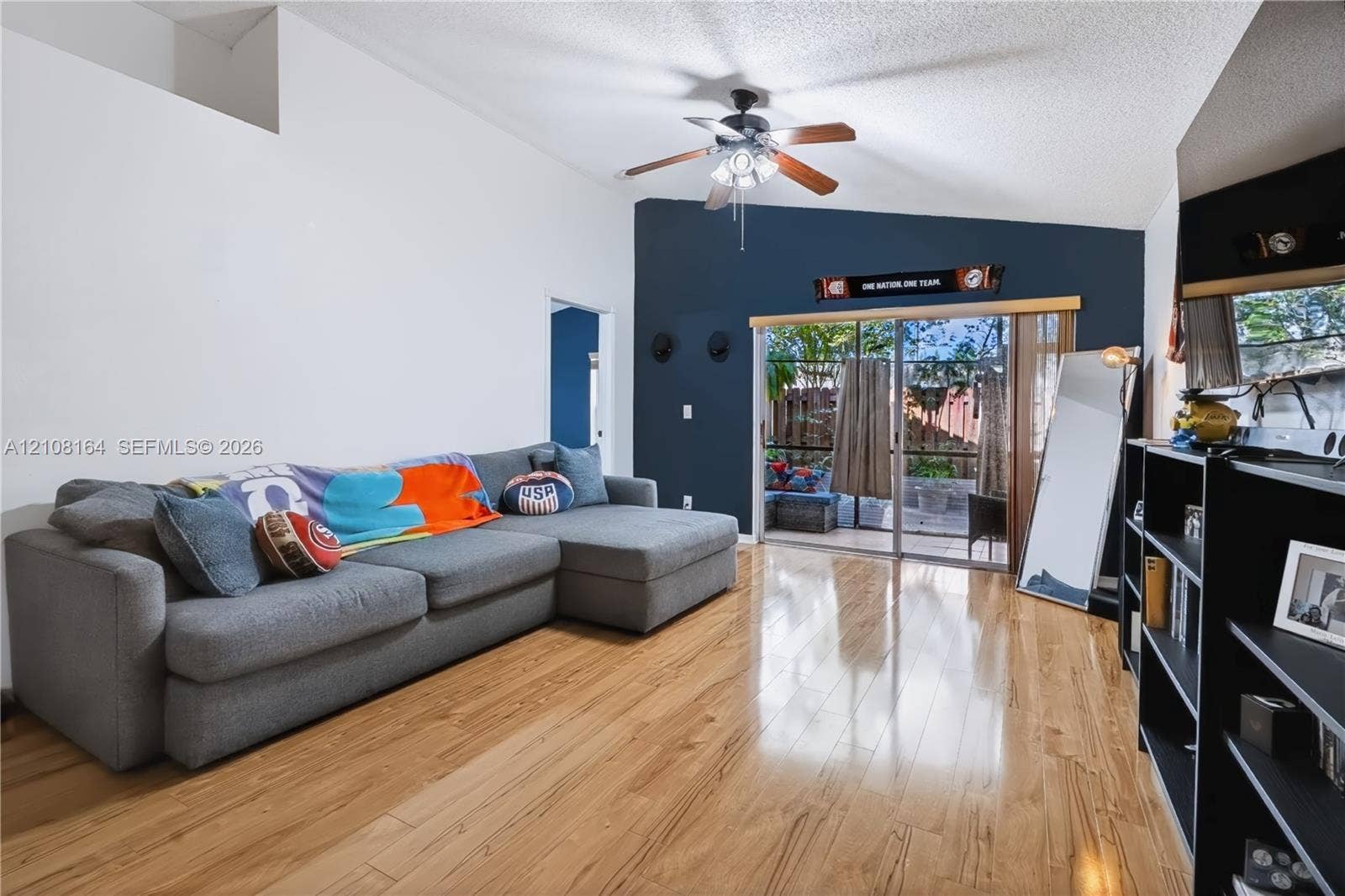 3983 NW 122nd Terrace, Sunrise, FL 33323 Vaulted ceiling with an integrated ceiling fan, wood-finish flooring, and sliding glass doors providing exterior access