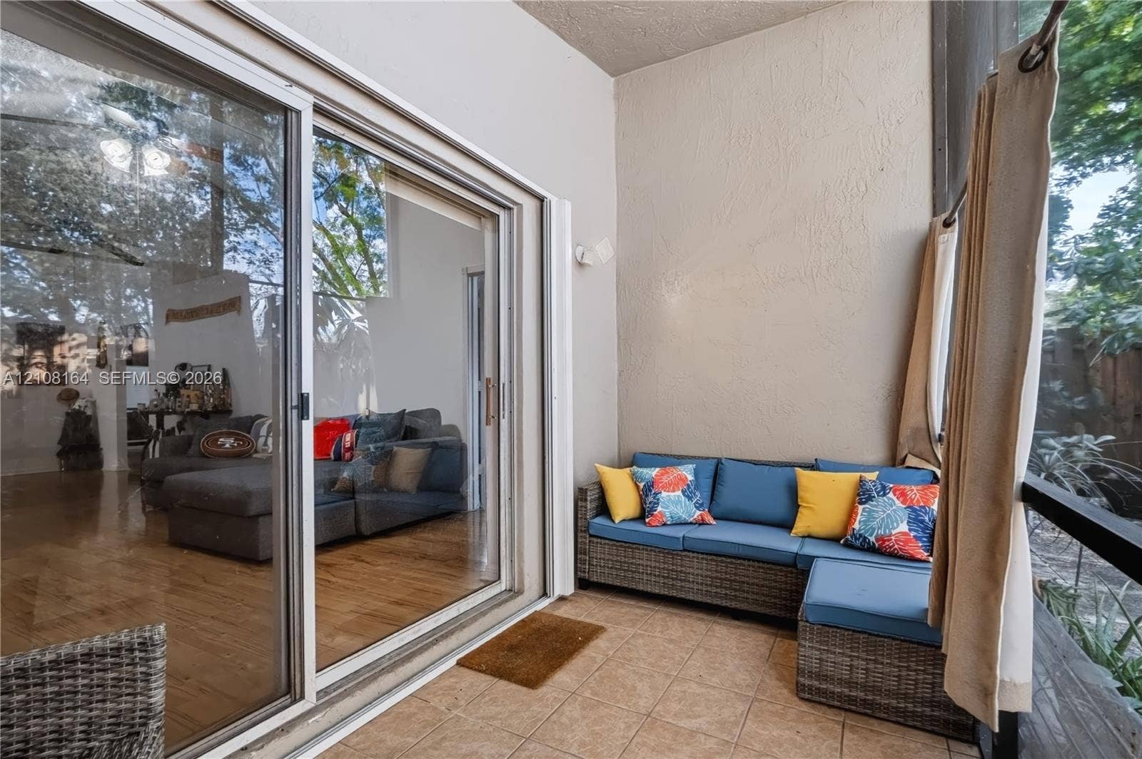 3983 NW 122nd Terrace, Sunrise, FL 33323 Screened-in patio featuring tile flooring, textured wall finishes, and sliding glass door entry