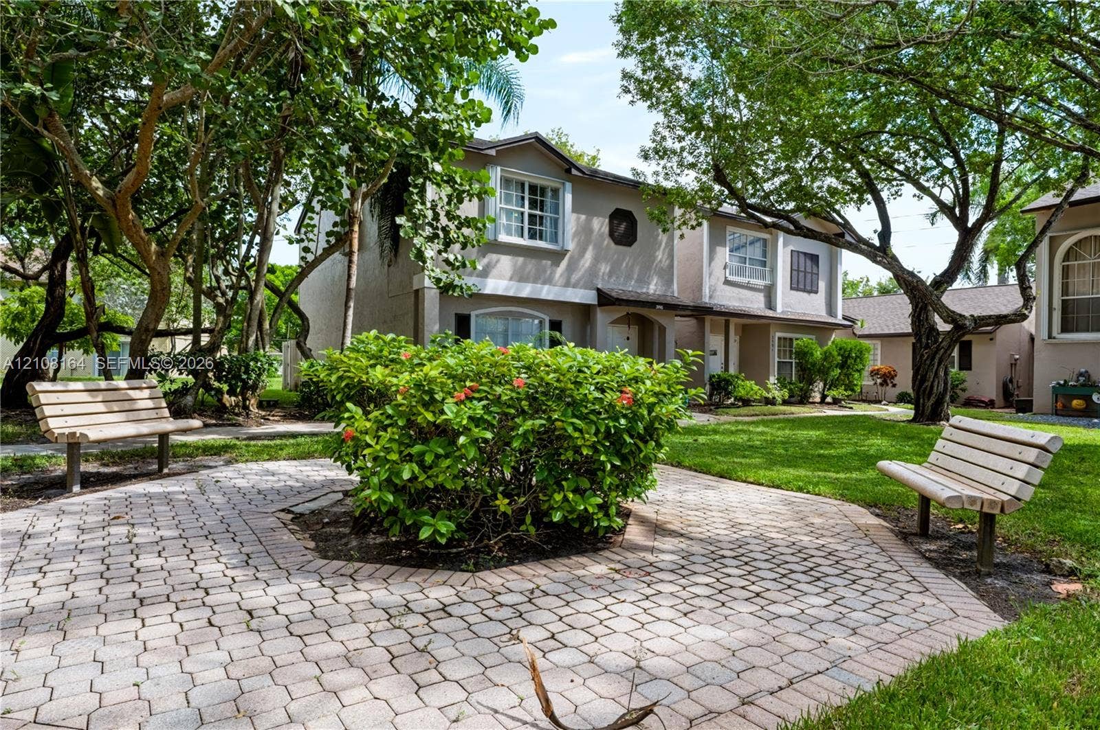 3983 NW 122nd Terrace, Sunrise, FL 33323 Paver-stone walkway featuring established landscaping, mature shade trees, and a manicured lawn