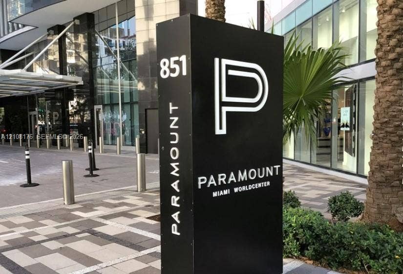 Paramount Miami Worldcenter monument signage featuring a black monolith finish, professional landscape integration, and stone-paver pedestrian walkway