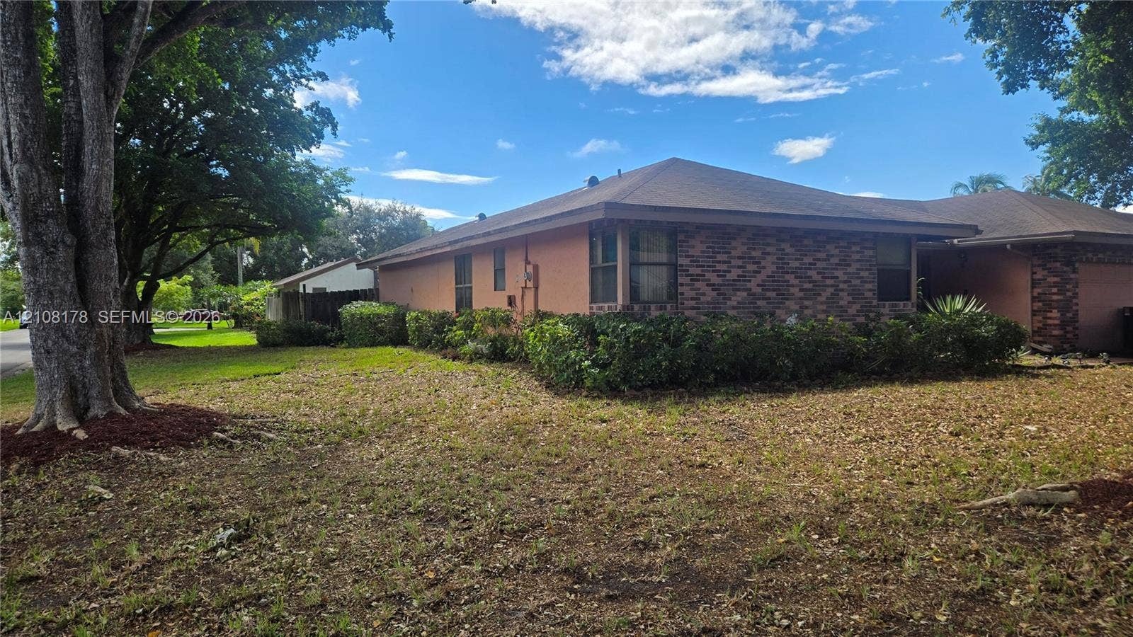 Coral Springs, FL 33065 Single-story exterior featuring a brick and stucco facade, hip roofline, and established landscaping