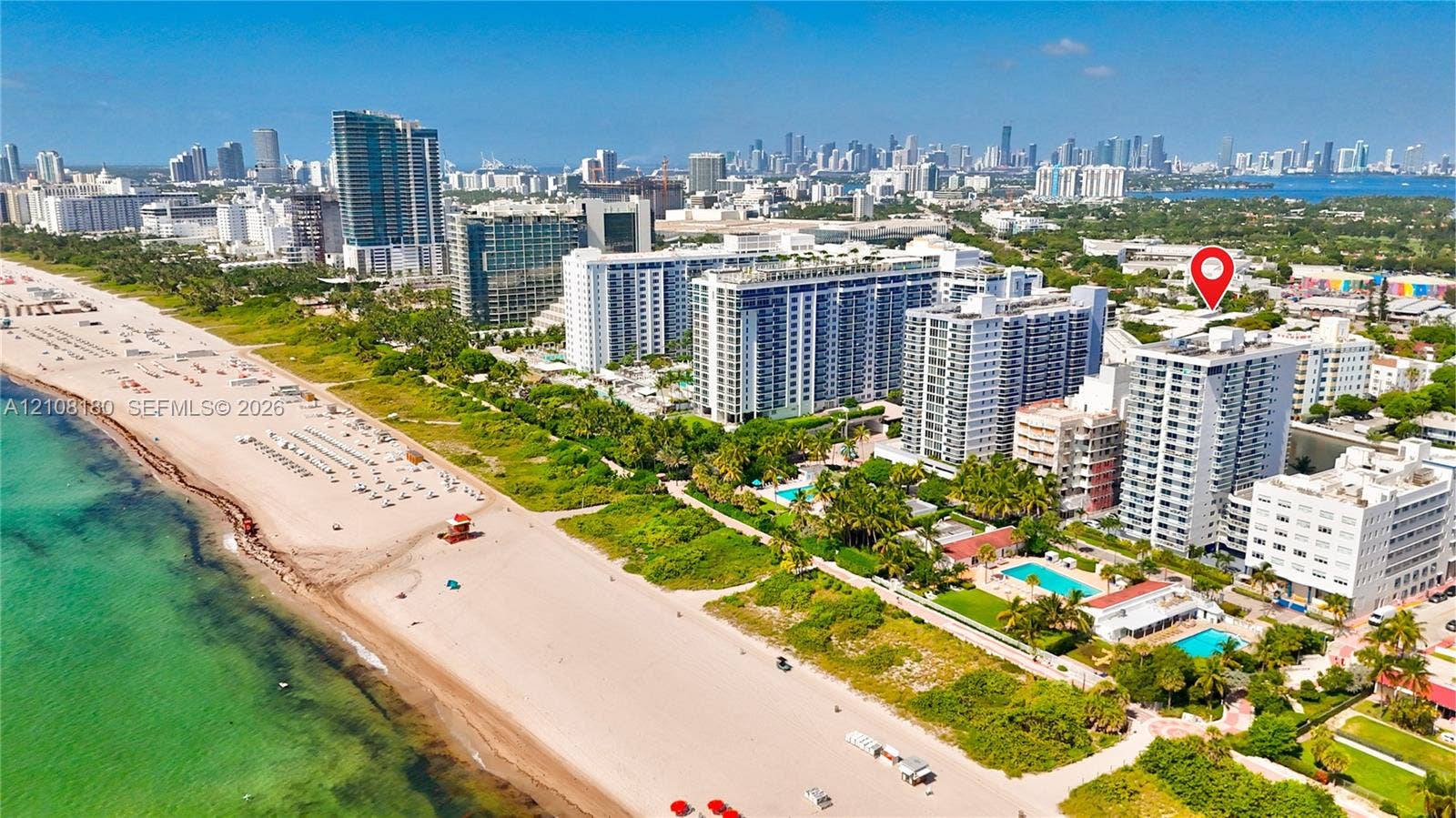 2457 Collins Avenue, #1501, Miami Beach, FL 33140 Aerial perspective of a multi-story residential building located in a coastal urban environment featuring immediate proximity to the Atlantic shoreline and surrounding high-rise infrastructure